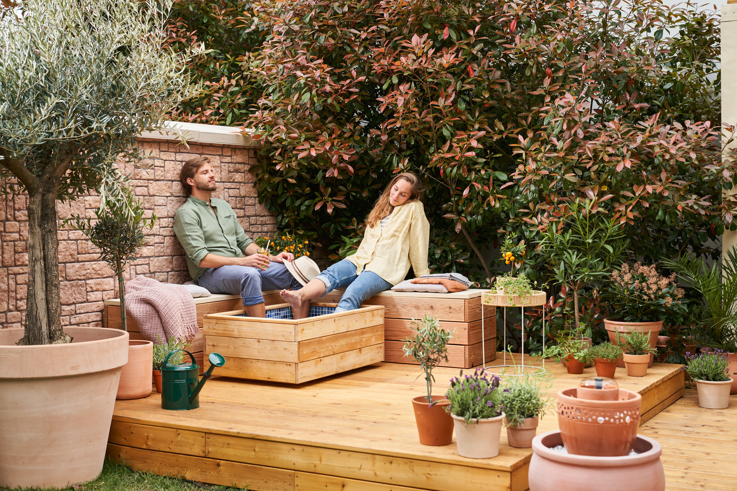 Pár sediaci na lavičkách s nohami v kúpeli pre nohy