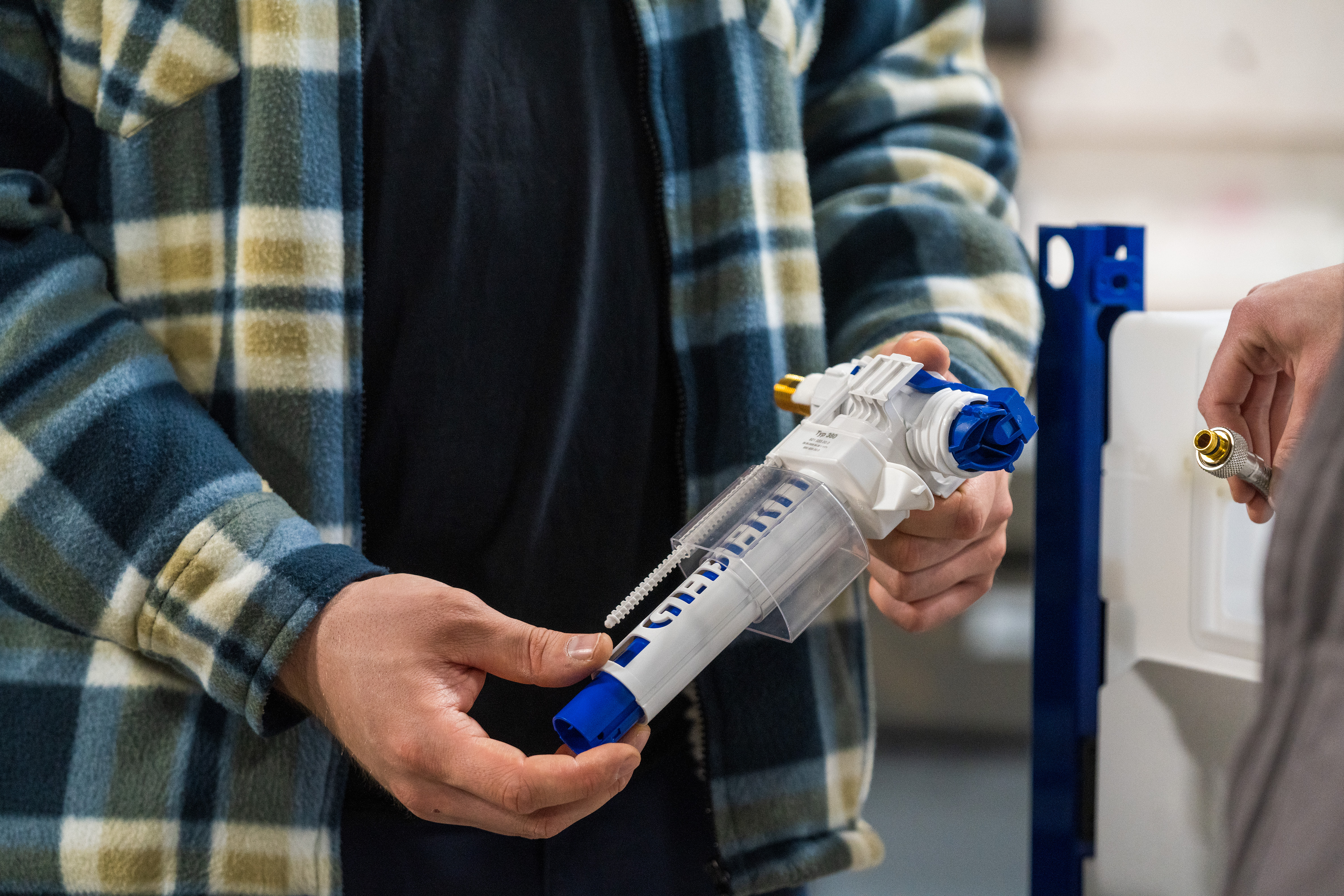 Handwerker hält ein neues Füllventil in den Händen.