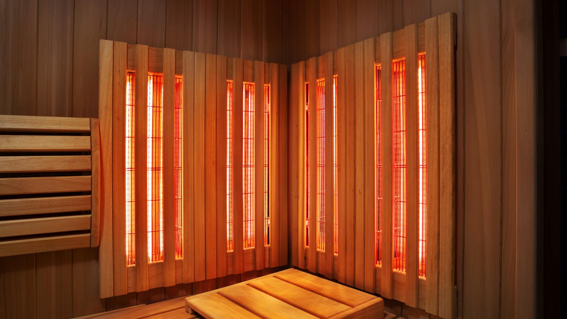 Liegefläche einer Infrarotkabine mit eingeschaltetem Infrarot-Licht an der Rückwand.
