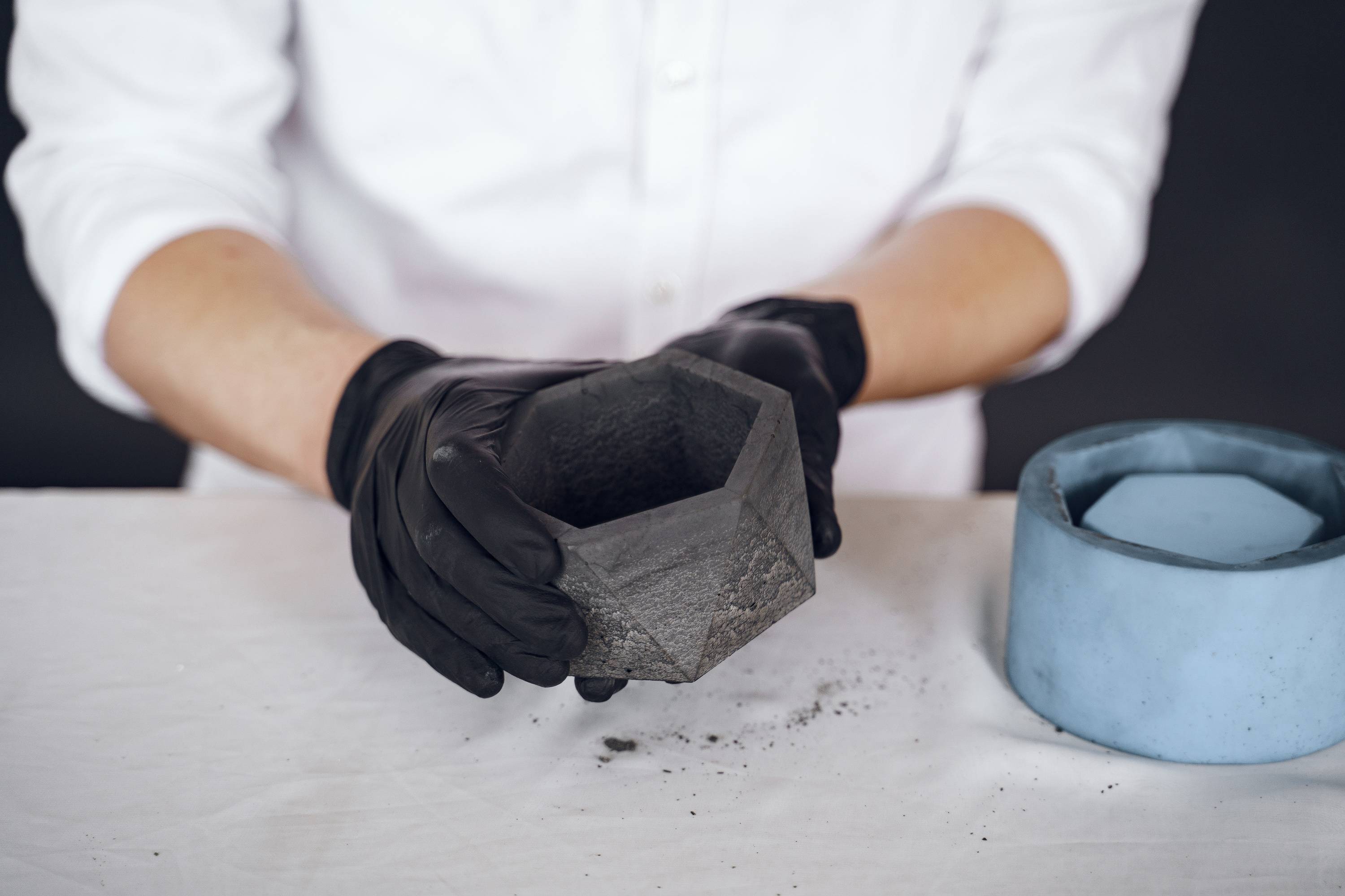 Mężczyzna pokazuje doniczkę z betonu DIY.