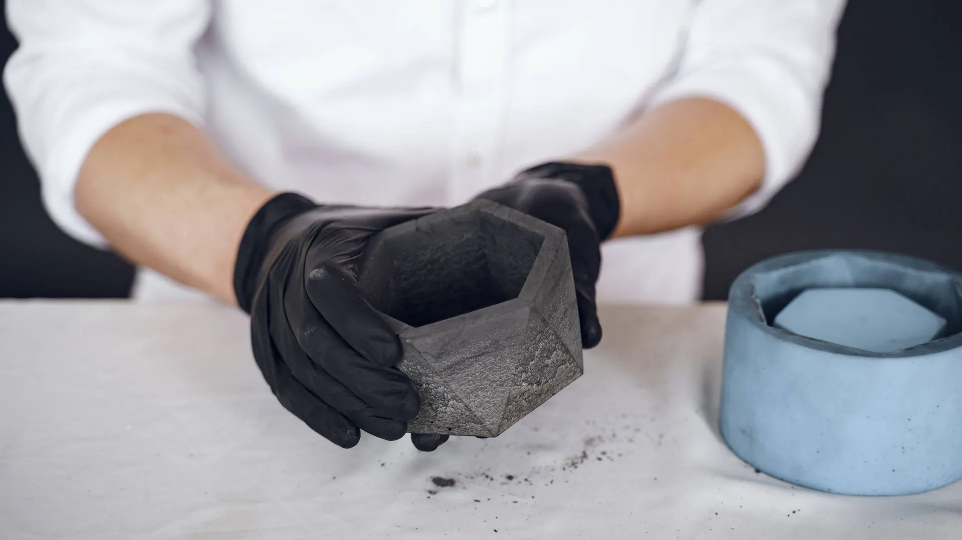 Mężczyzna pokazuje doniczkę z betonu DIY.