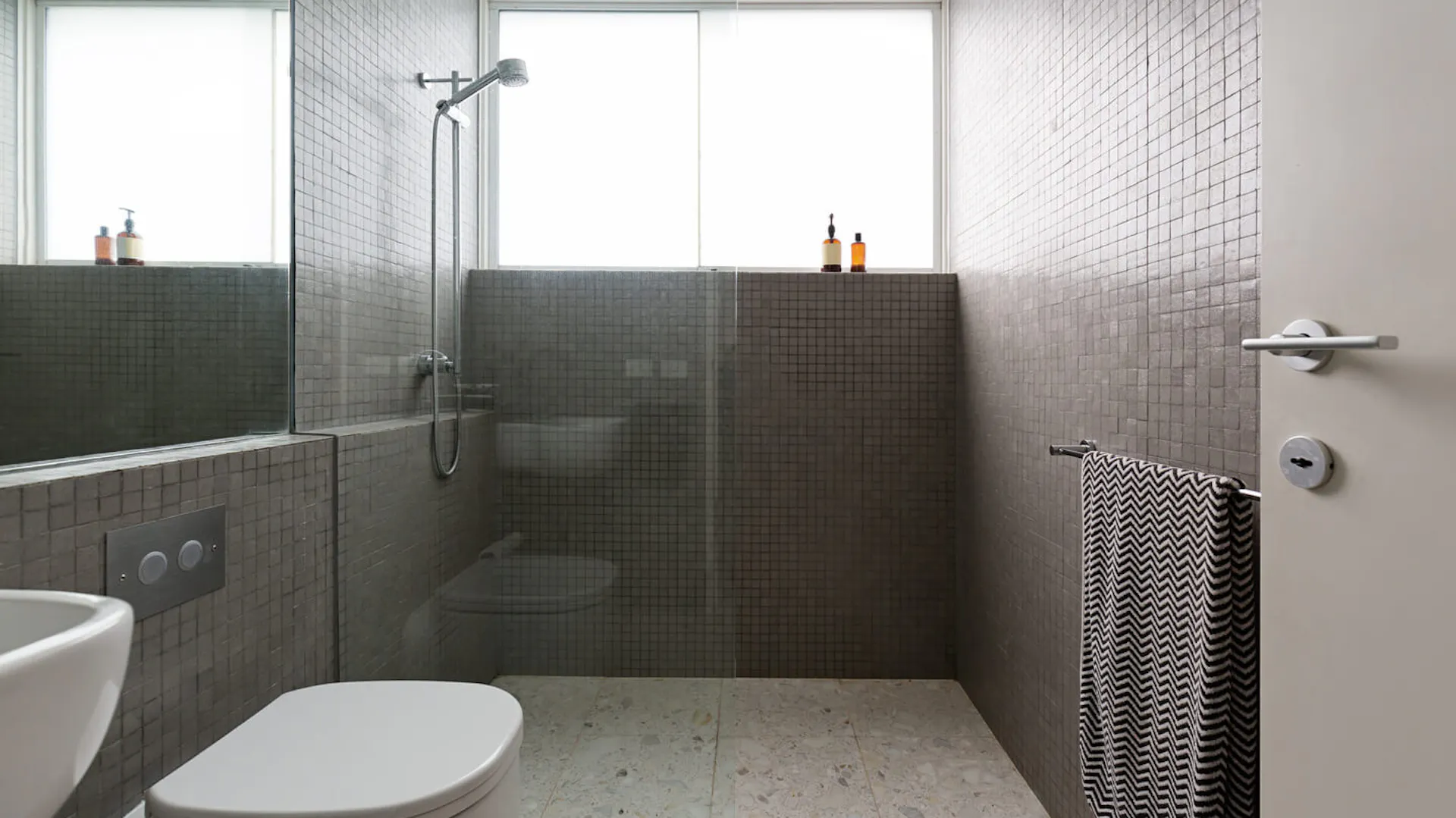 Prysznic walk-in w szarej łazience.