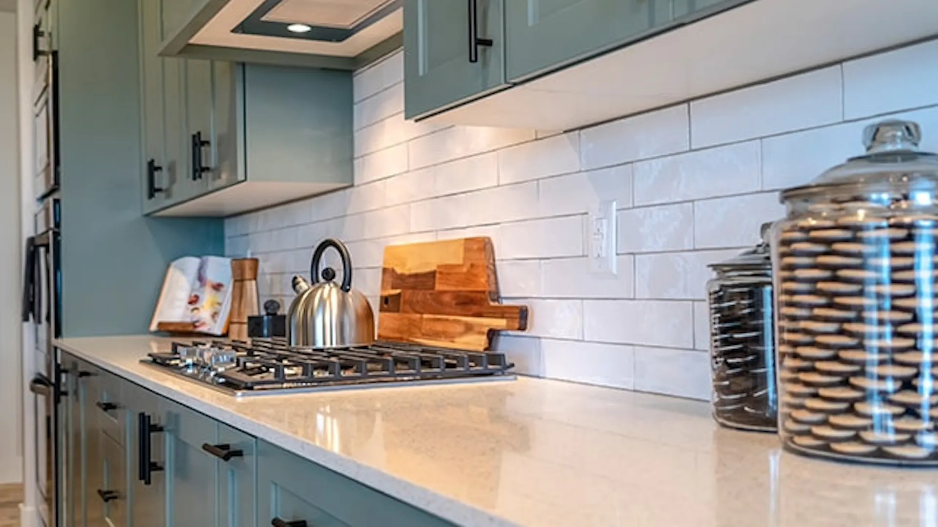 Szara kuchnia z jasnym blatem kuchennym i płytą gazową.