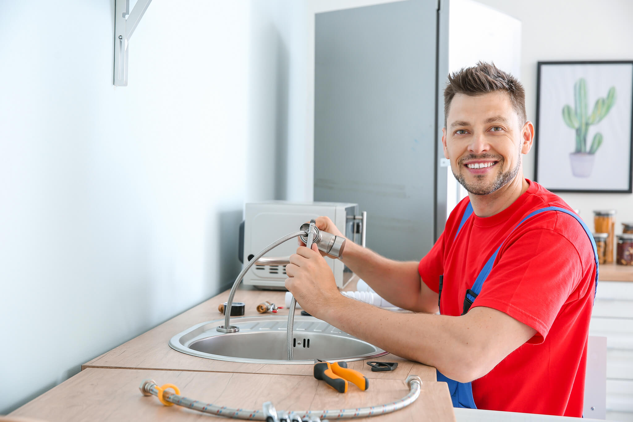 Uśmiechnięty mężczyzna montuje baterię kuchenną