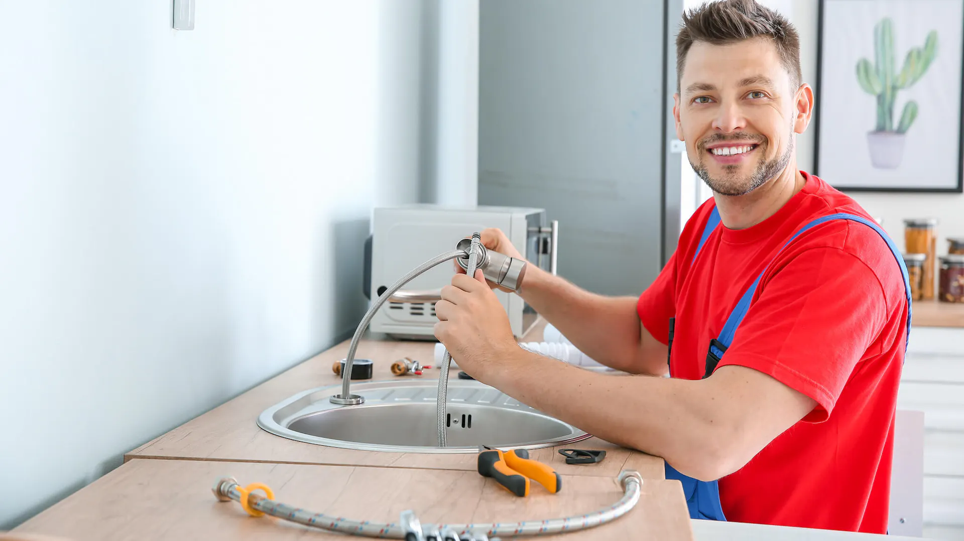 Uśmiechnięty mężczyzna montuje baterię kuchenną