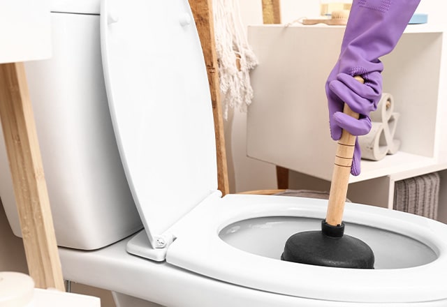 Udrożnianie WC za pomocą gumowej przepychaczki.