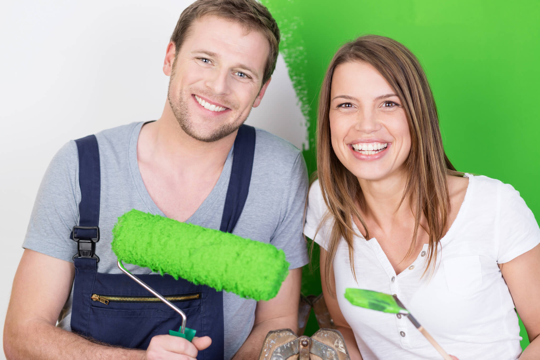 Kobieta i mężczyzna uśmiechają się na myśl, jaką dobrą farbę do malowania ścian wybrali