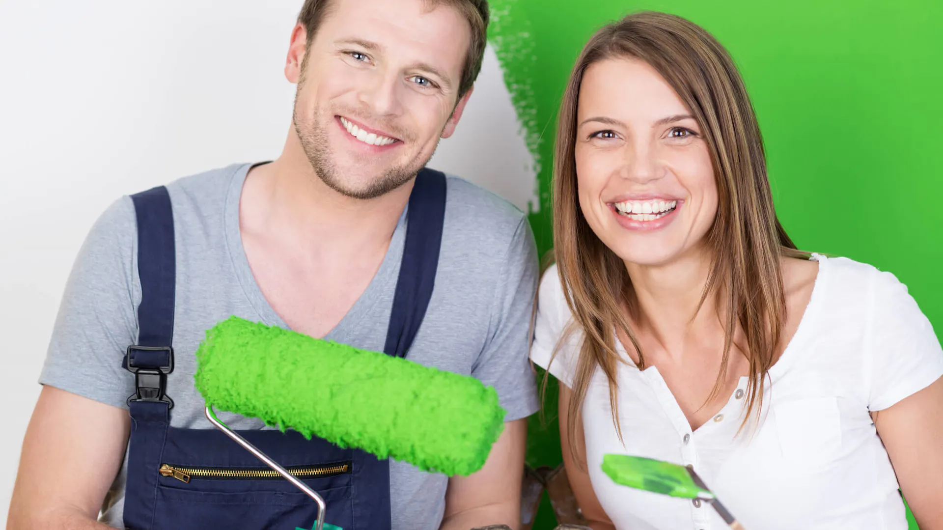 Kobieta i mężczyzna uśmiechają się na myśl, jaką dobrą farbę do malowania ścian wybrali