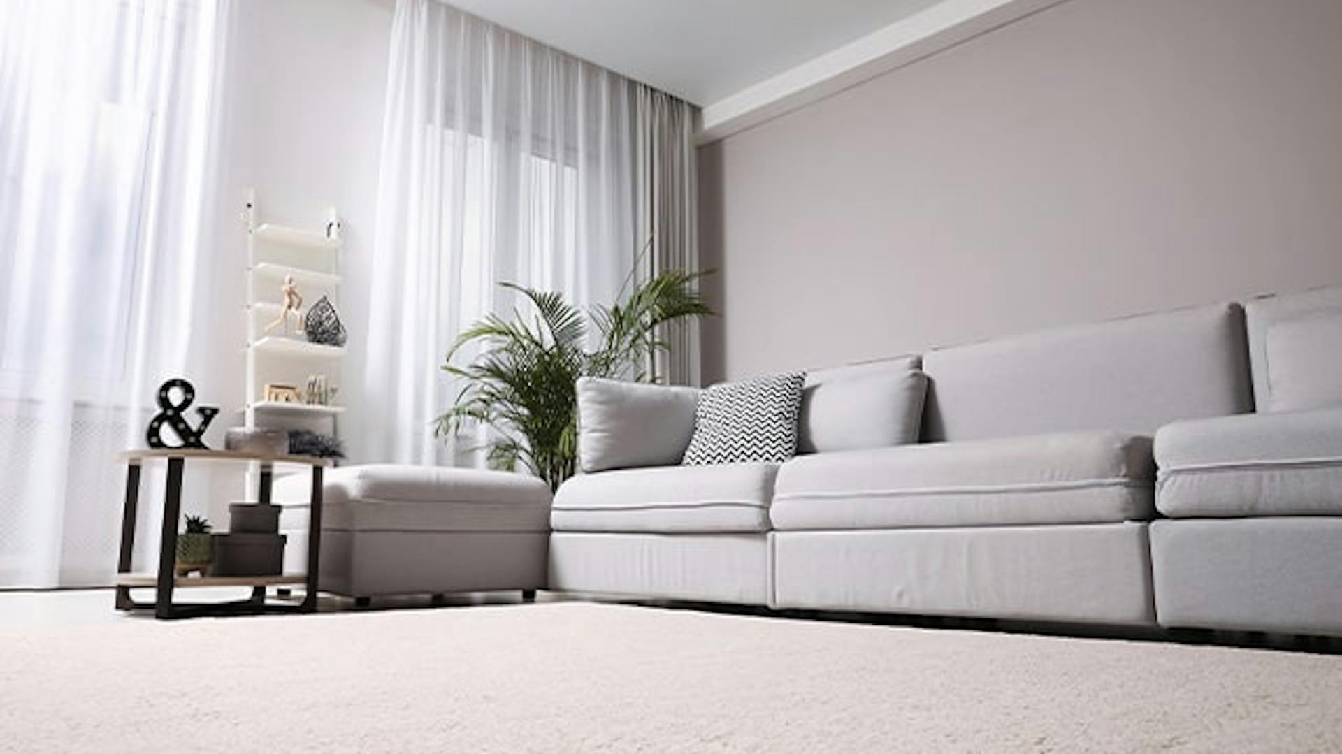 Salon w odcieniach szarości z miękką wykładziną podłogową.