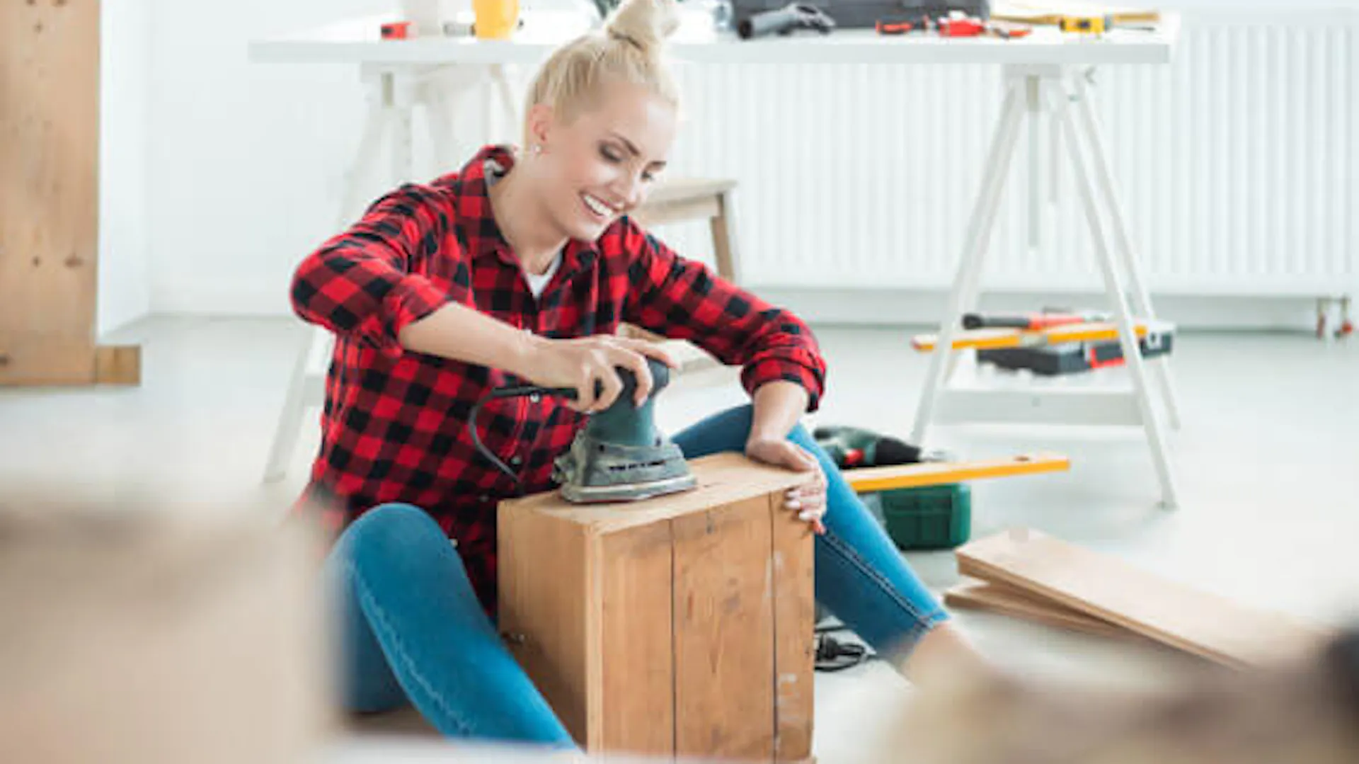 Kobieta szlifuje drewniany mebel wykonując w domu projekt DIY