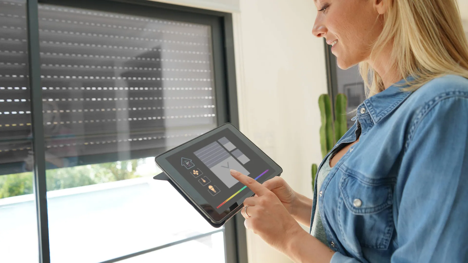 Kobieta z tabletem korzystająca z systemu automatyki domowej