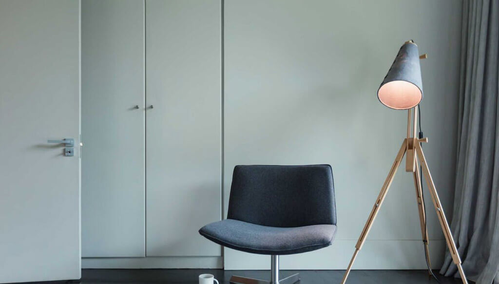 Lampa stojąca zdobi sypialnię lub biuro.