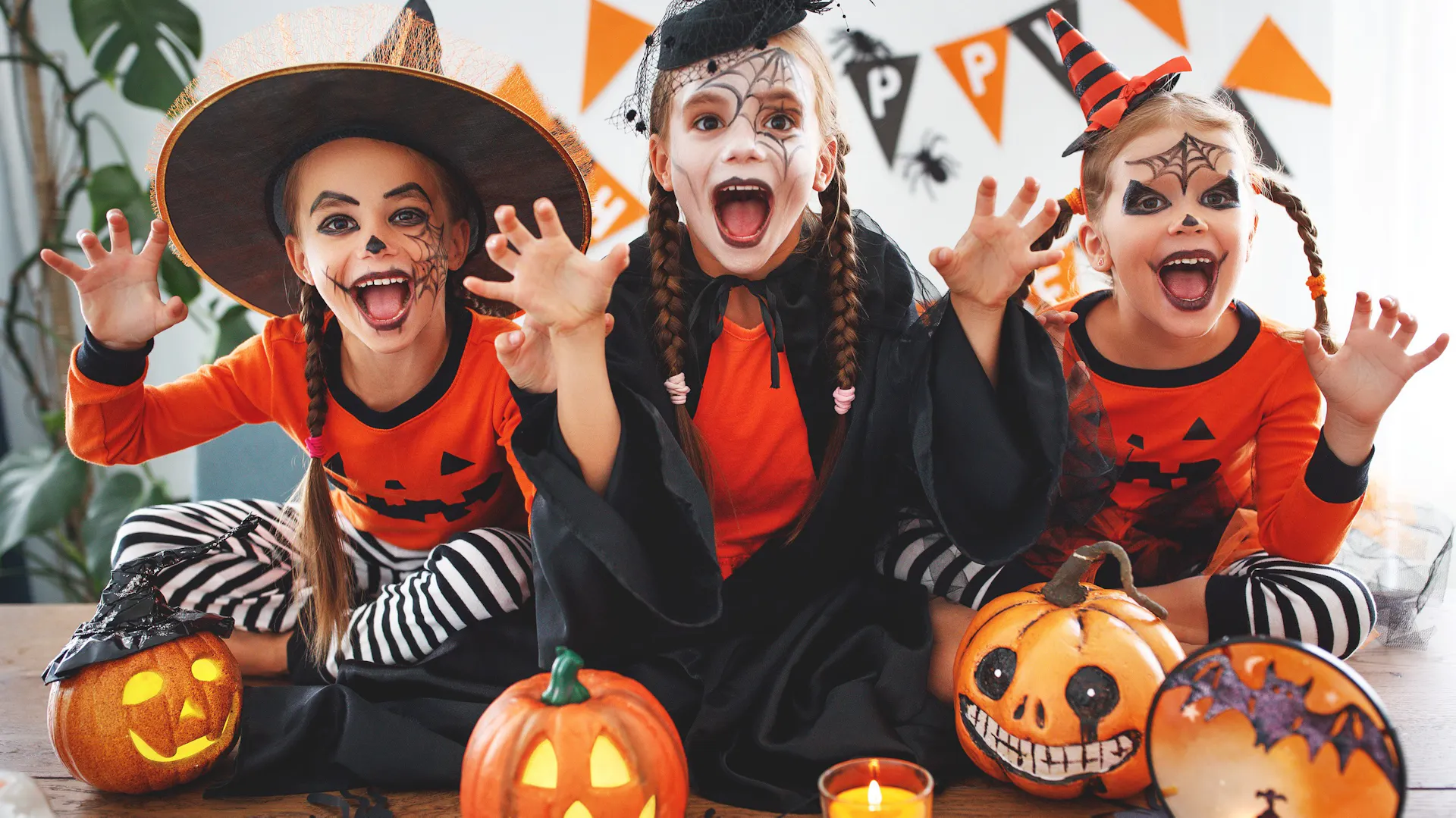 Dzieci bawią się na imprezie Halloween, mają halloweenowe przebrania i dekoracje