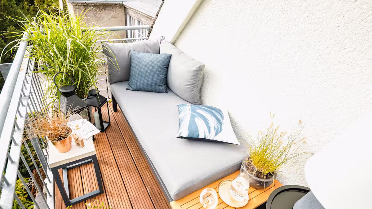 Mały balkon z roślinami i małą sofą