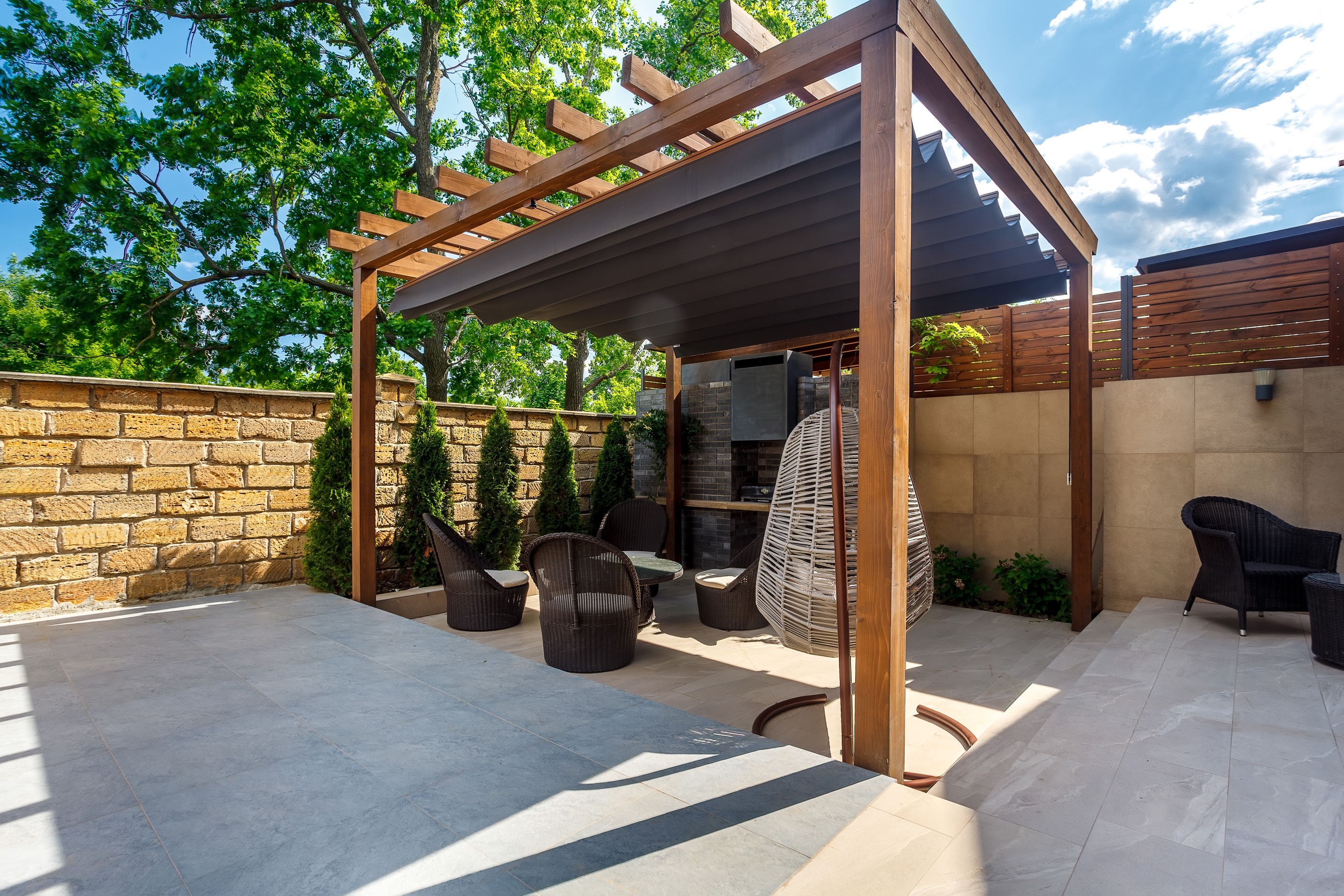 Pergola tarasowa z wygodnymi meblami tworzy przytulną przestrzeń wypoczynku.