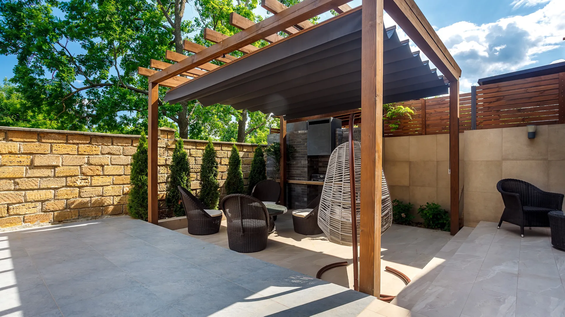 Pergola tarasowa z wygodnymi meblami tworzy przytulną przestrzeń wypoczynku.