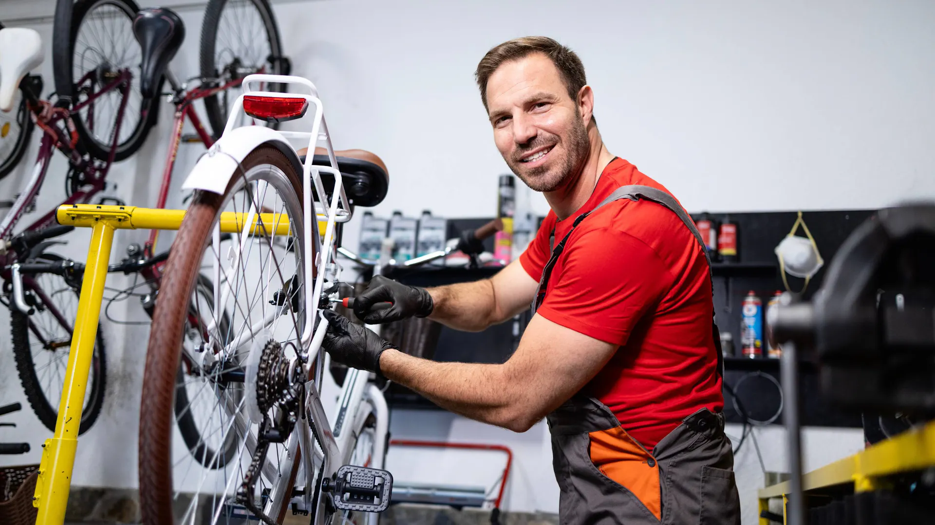 Uśmiechnięty mężczyzna w warsztacie rowerowym