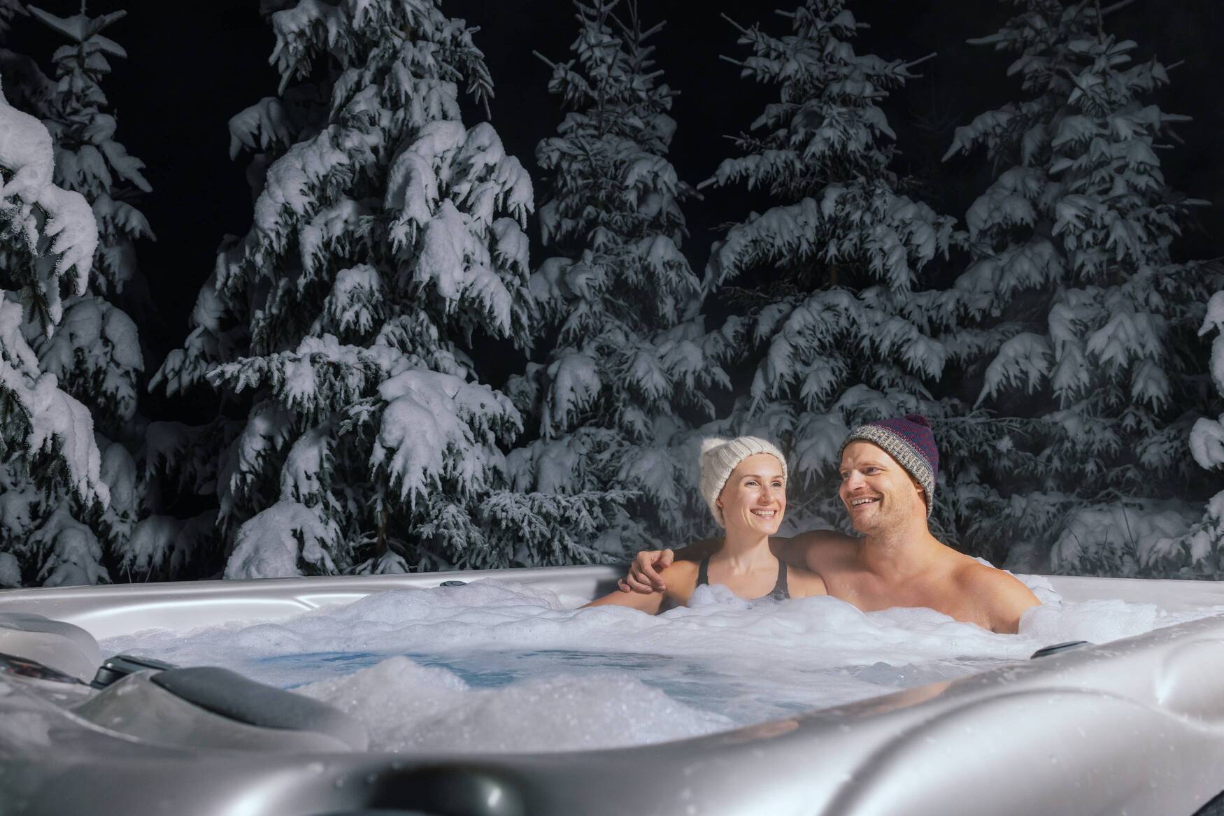 Mężczyzna i kobieta korzystają z kąpieli w jacuzzi zimą