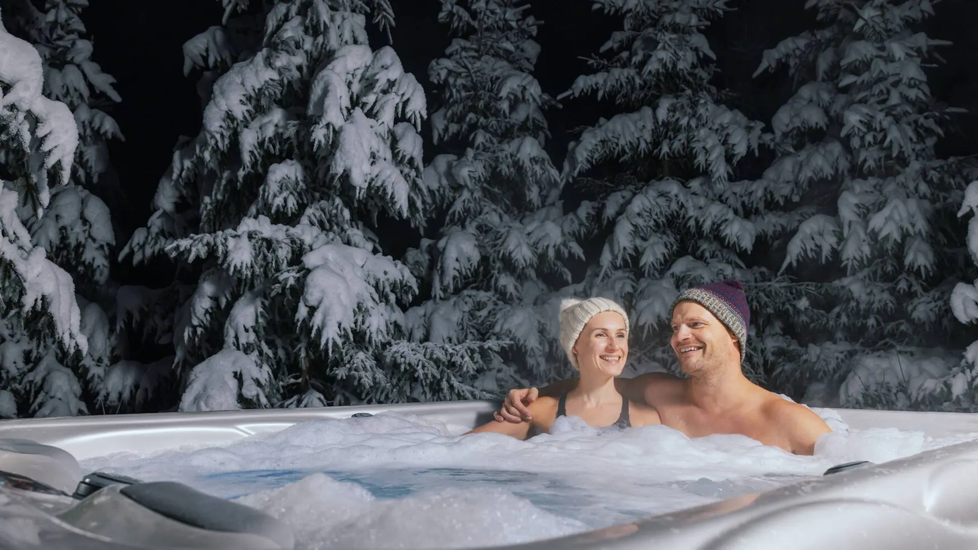 Mężczyzna i kobieta korzystają z kąpieli w jacuzzi zimą