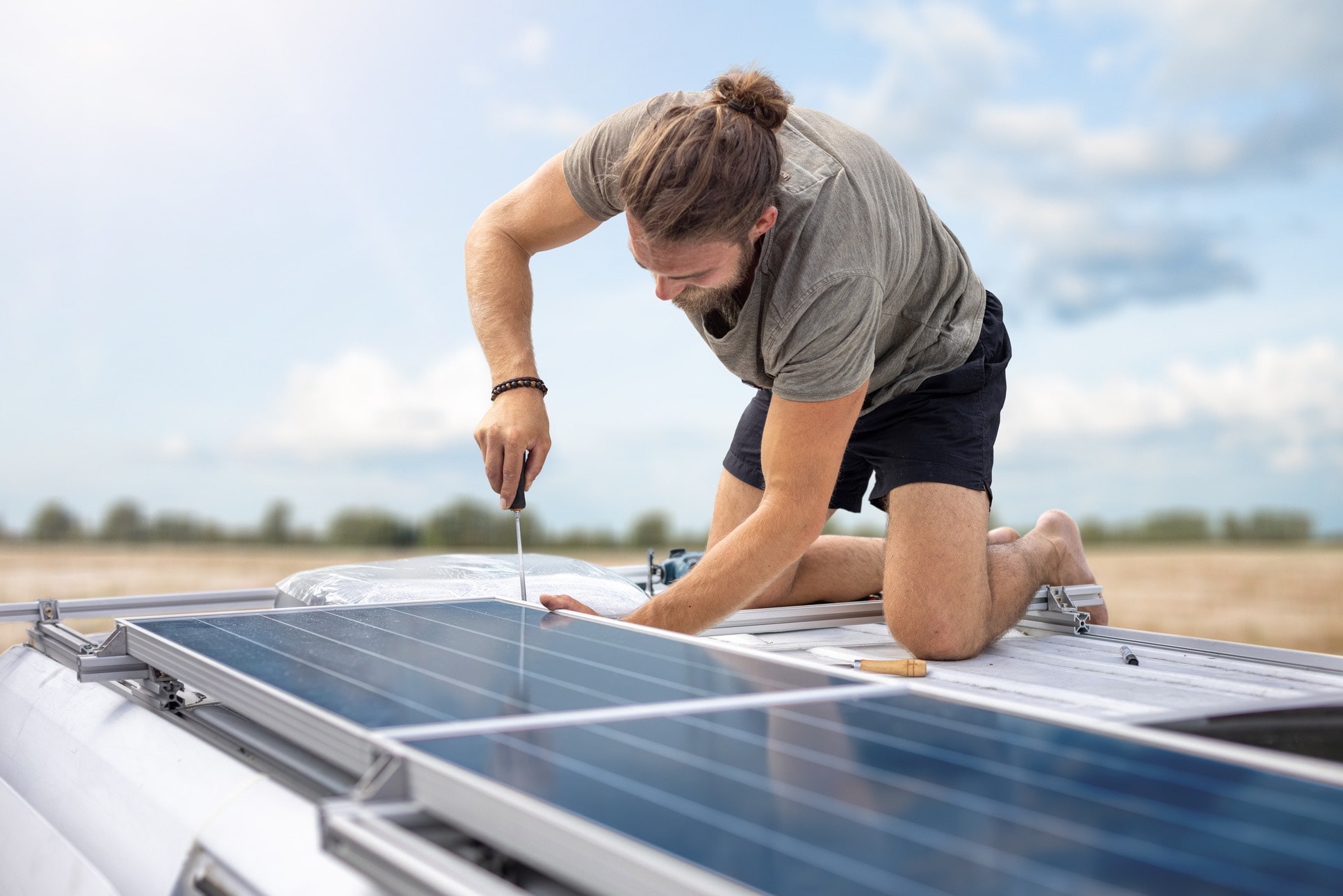Mężczyzna montuje panele solarne na kamperze