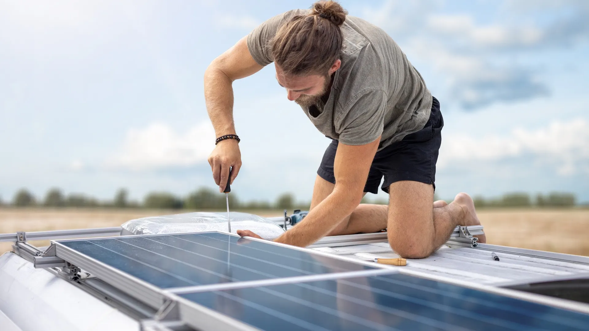Mężczyzna montuje panele solarne na kamperze