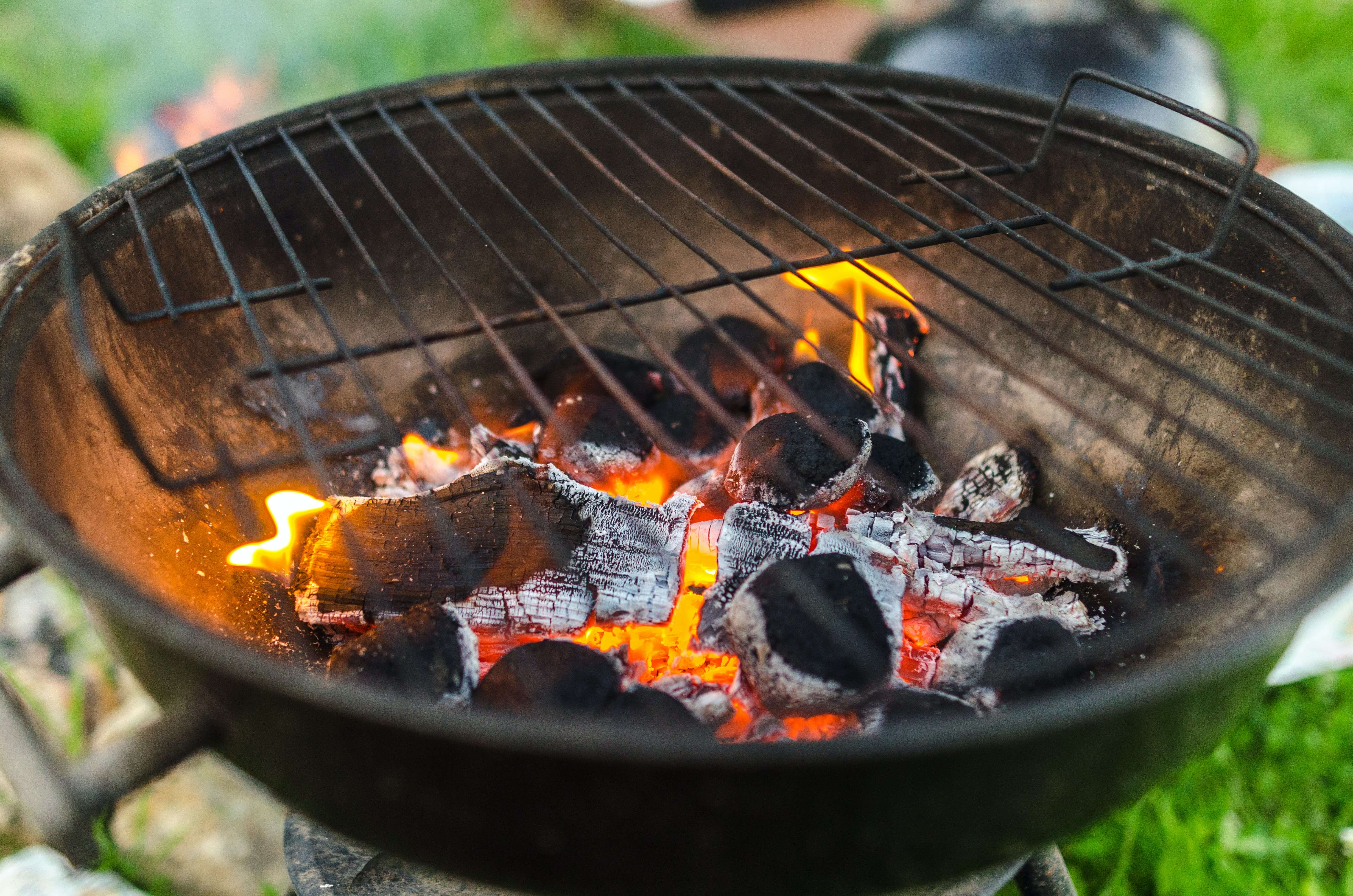 Okrągły grill węglowy. Wewnątrz rozżarzone węgle.