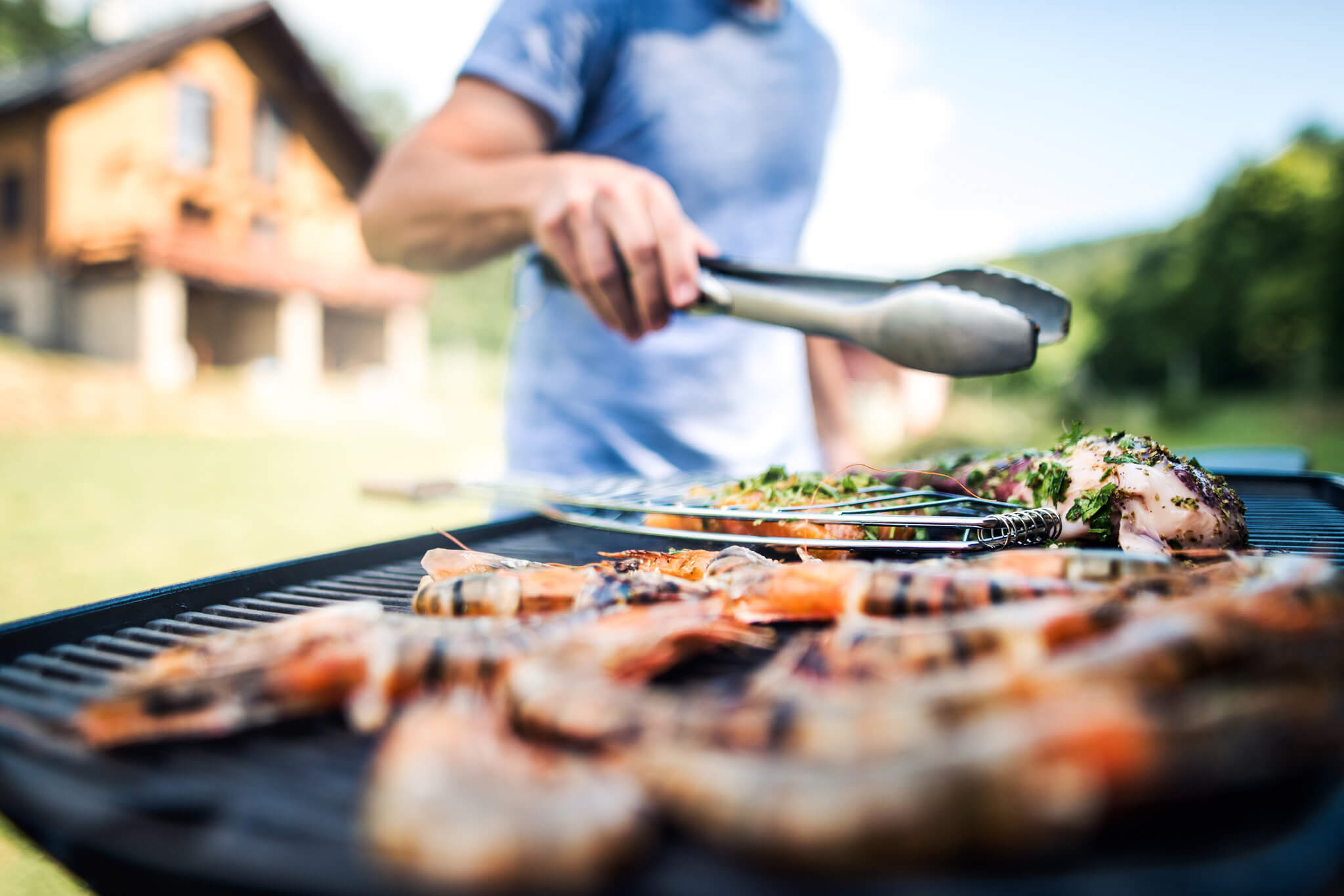 Mężczyzna przyrządza mięsa na grillu elektrycznym