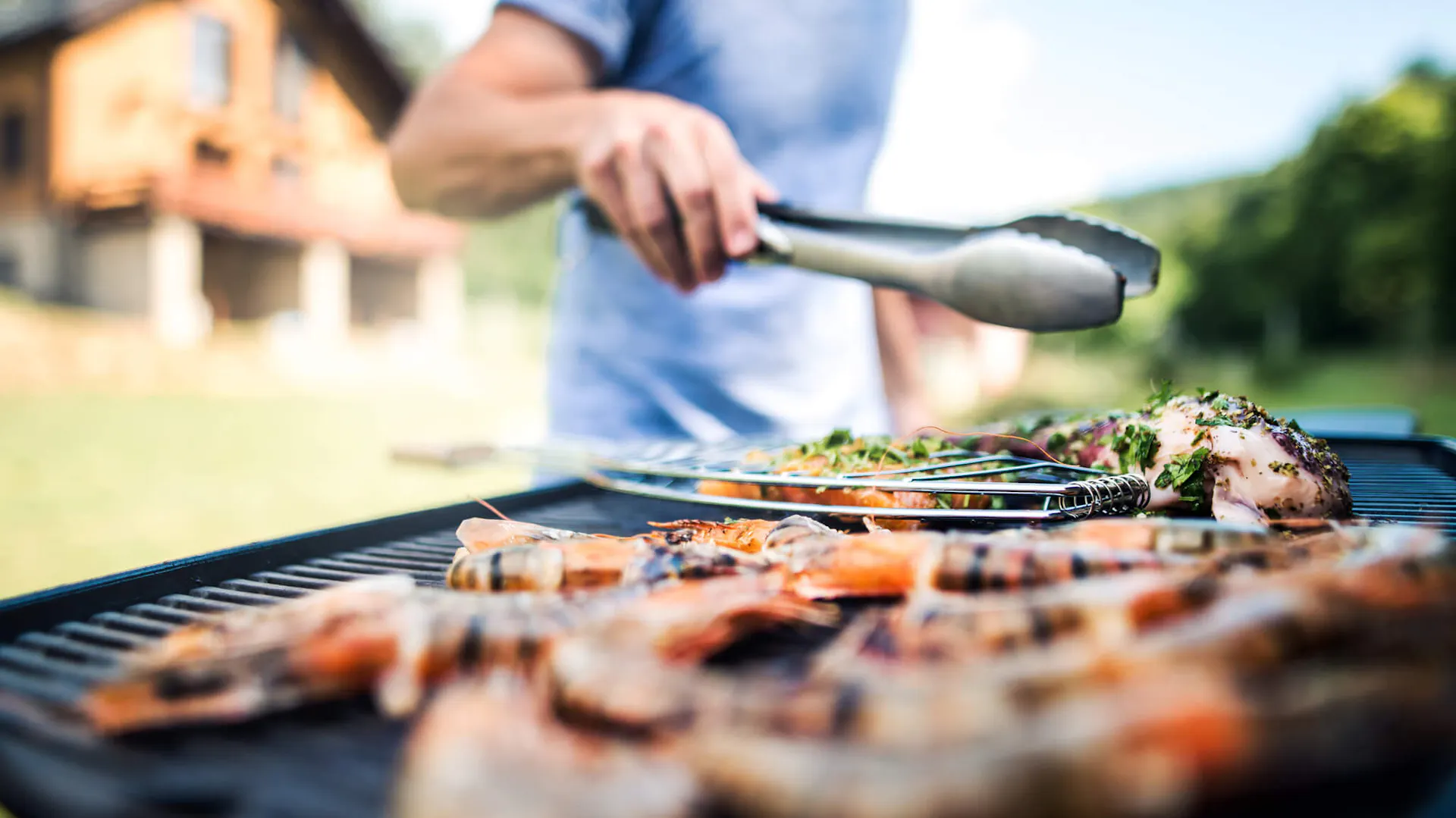 Mężczyzna przyrządza mięsa na grillu elektrycznym