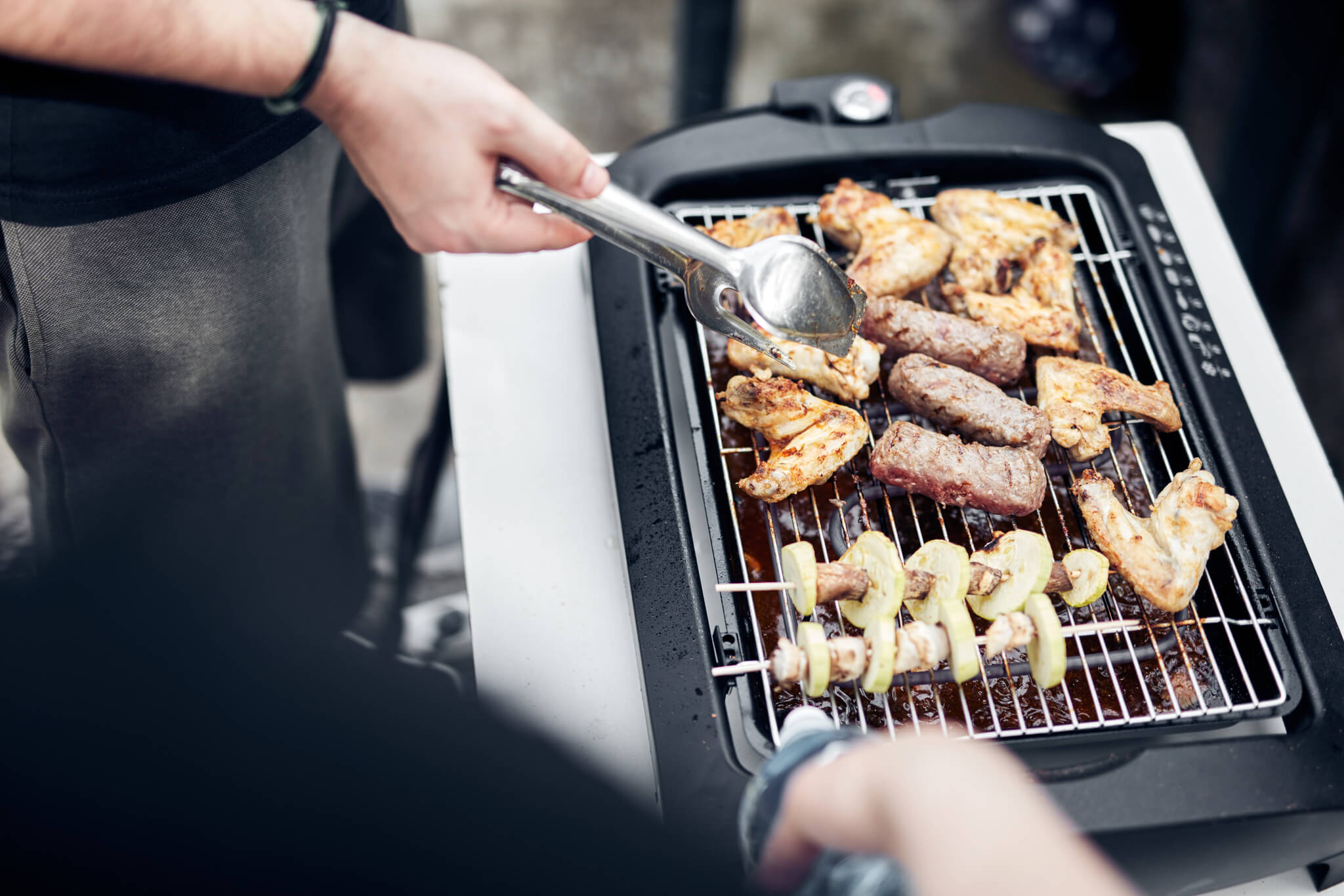Mężczyzna przygotowuje danie na grillu elektrycznym