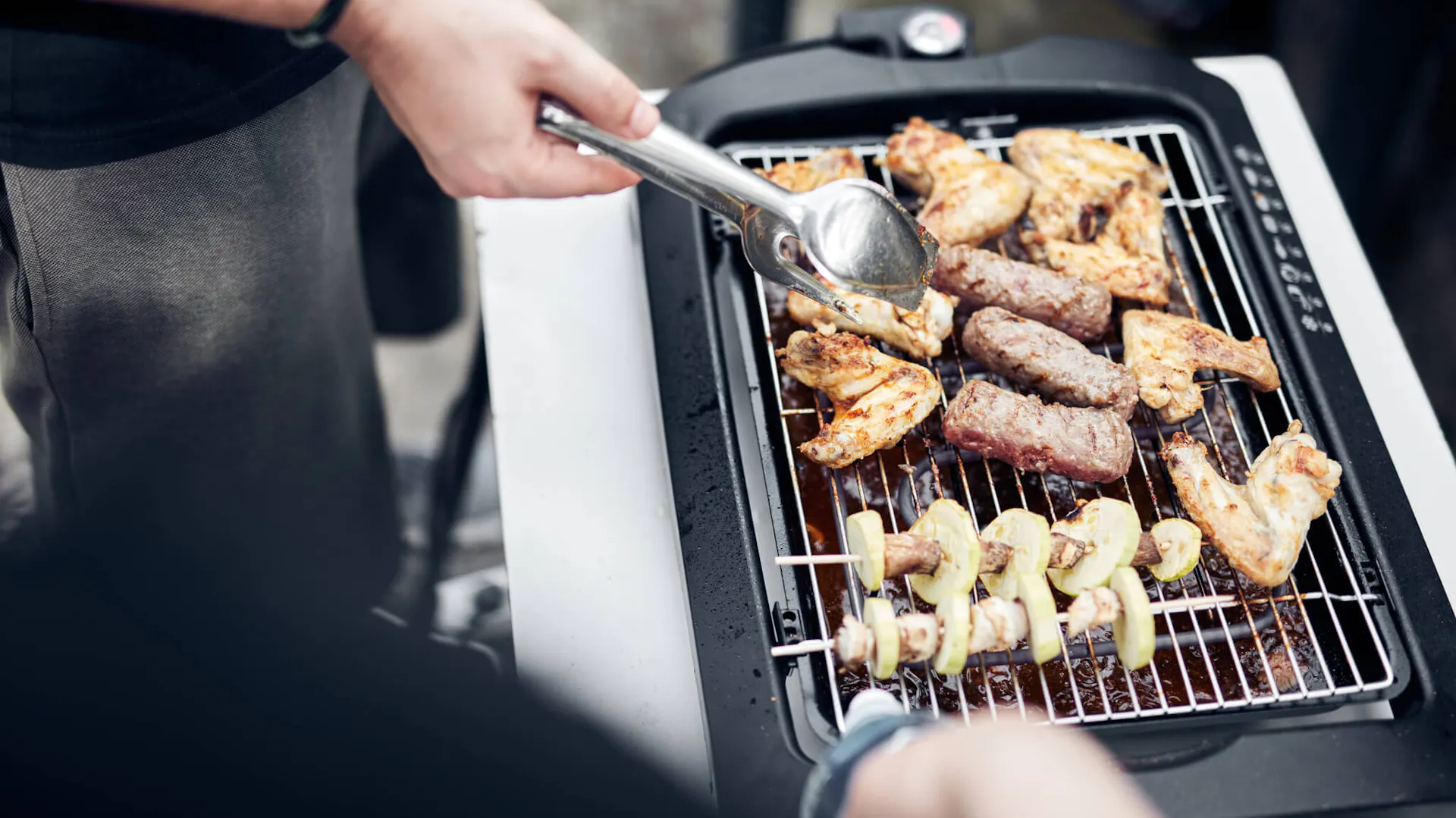Mężczyzna przygotowuje danie na grillu elektrycznym