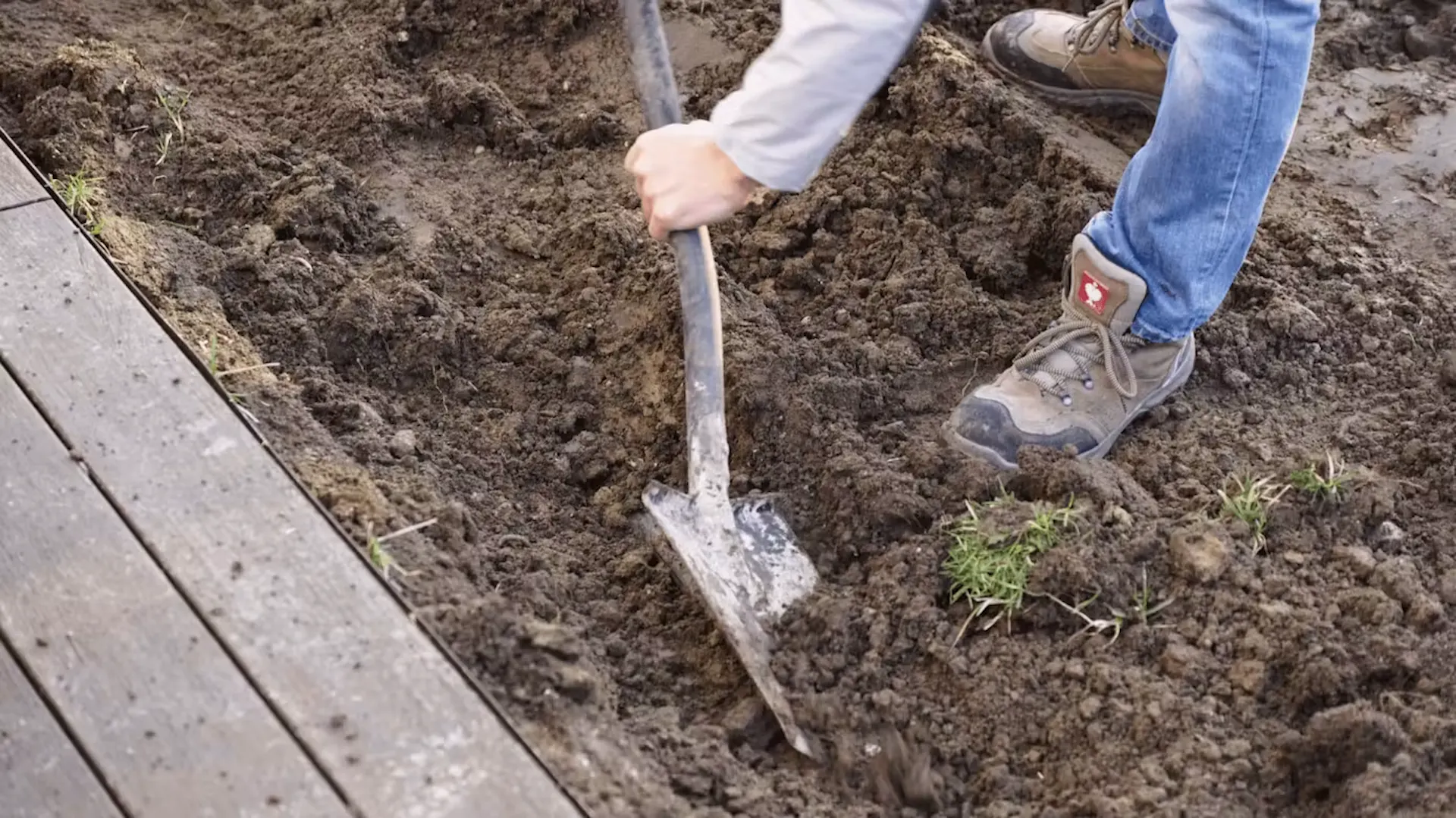 Mężczyzna wykopuje dół pod budowę basenu w ogrodzie