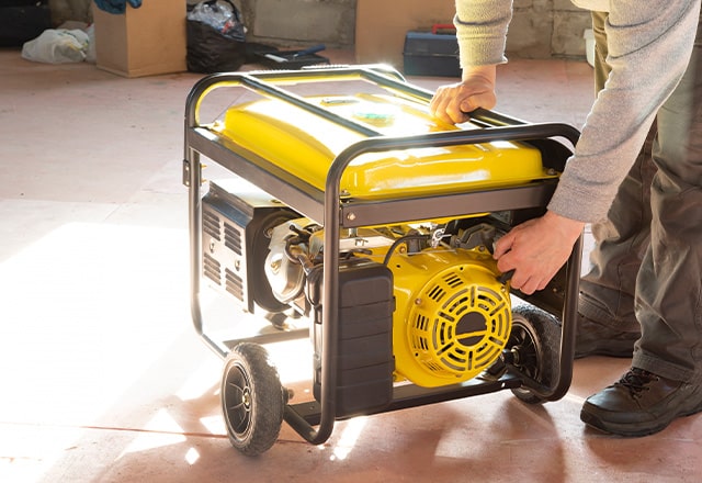 Osoba uruchamia generator prądu.