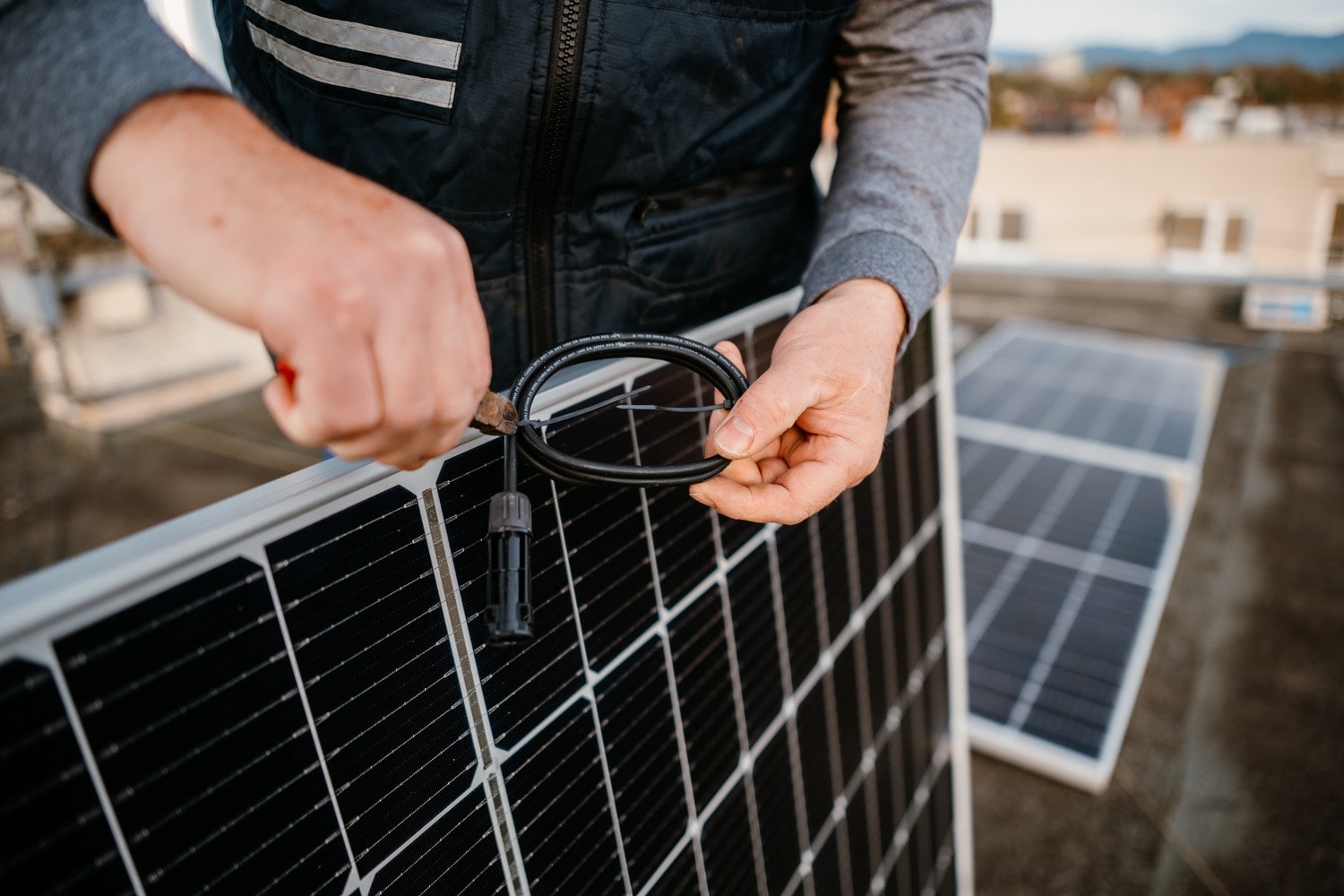 Mężczyzna montuje panele solarne na dachu budynku