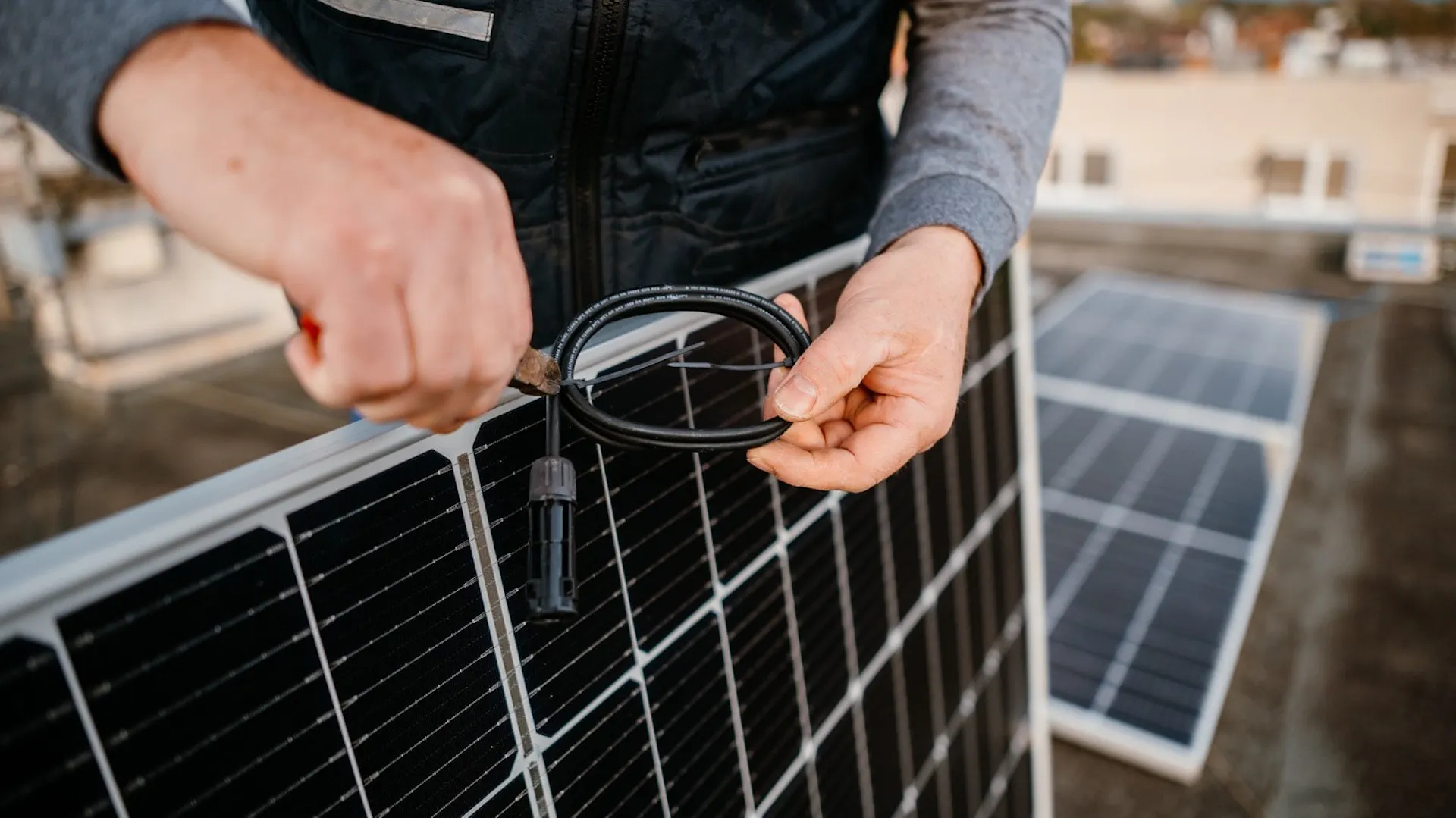 Mężczyzna montuje panele solarne na dachu budynku