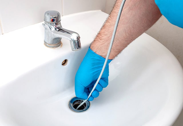 Usuwanie włosów z odpływu przy użyciu sprężyny hydraulicznej.