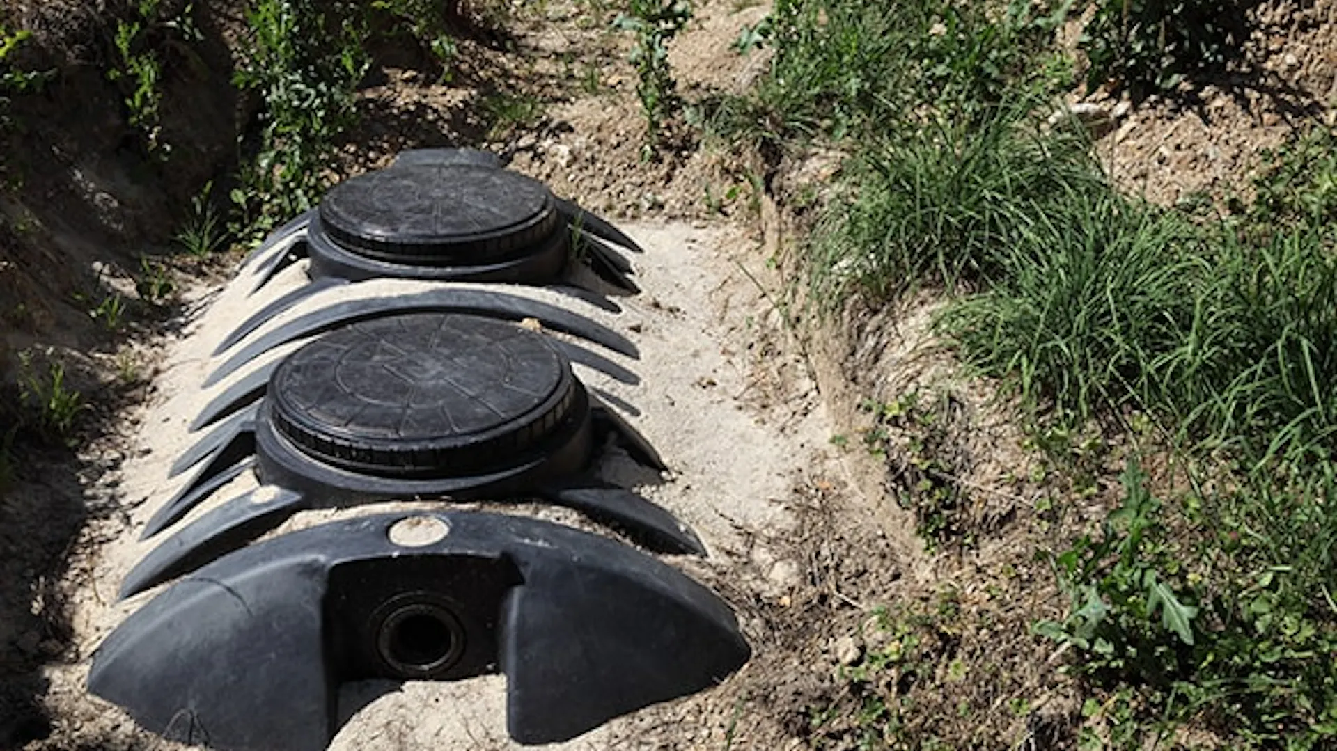 Zbiornik domowej oczyszczalni ścieków wkopany w ziemię.