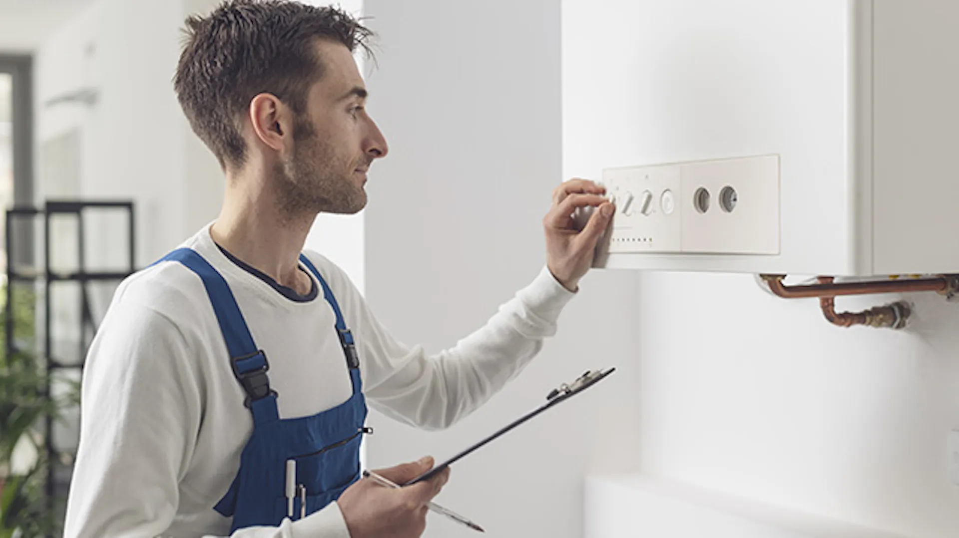 Mężczyzna reguluje piec gazowy.