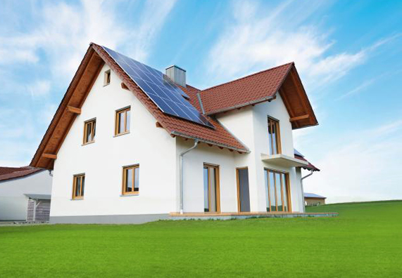 Dom jednorodzinny z instalacją solarną i zielonym trawnikiem.
