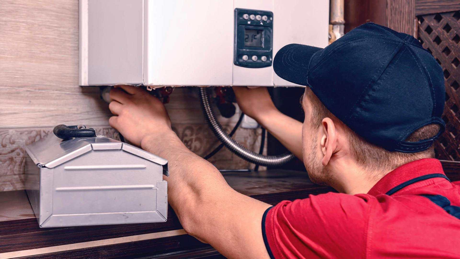 Mężczyzna podłącza przewody do grzejnika