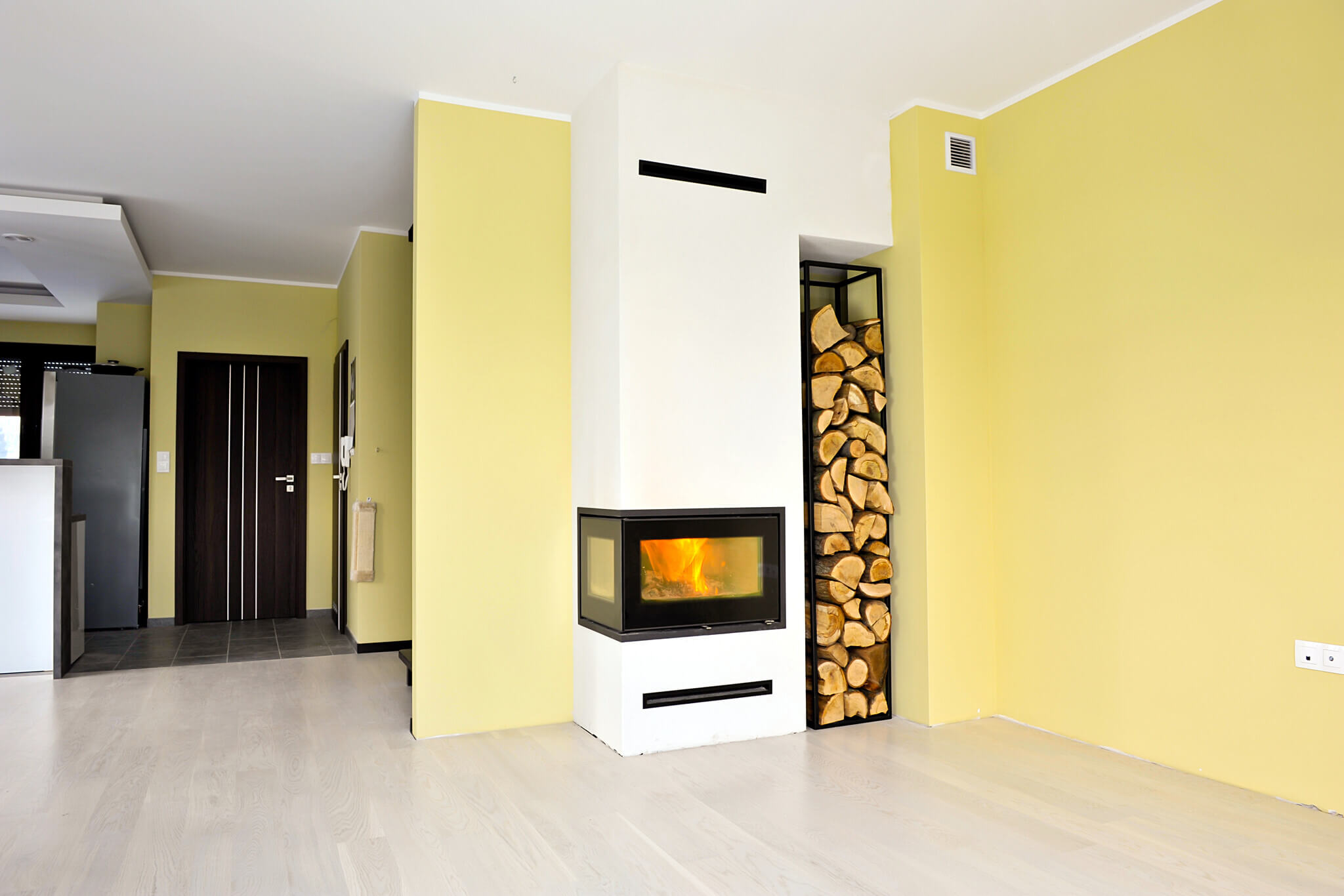 Majsterkowicze przed swoim nowym kominkiem, w którym płonie ogień.