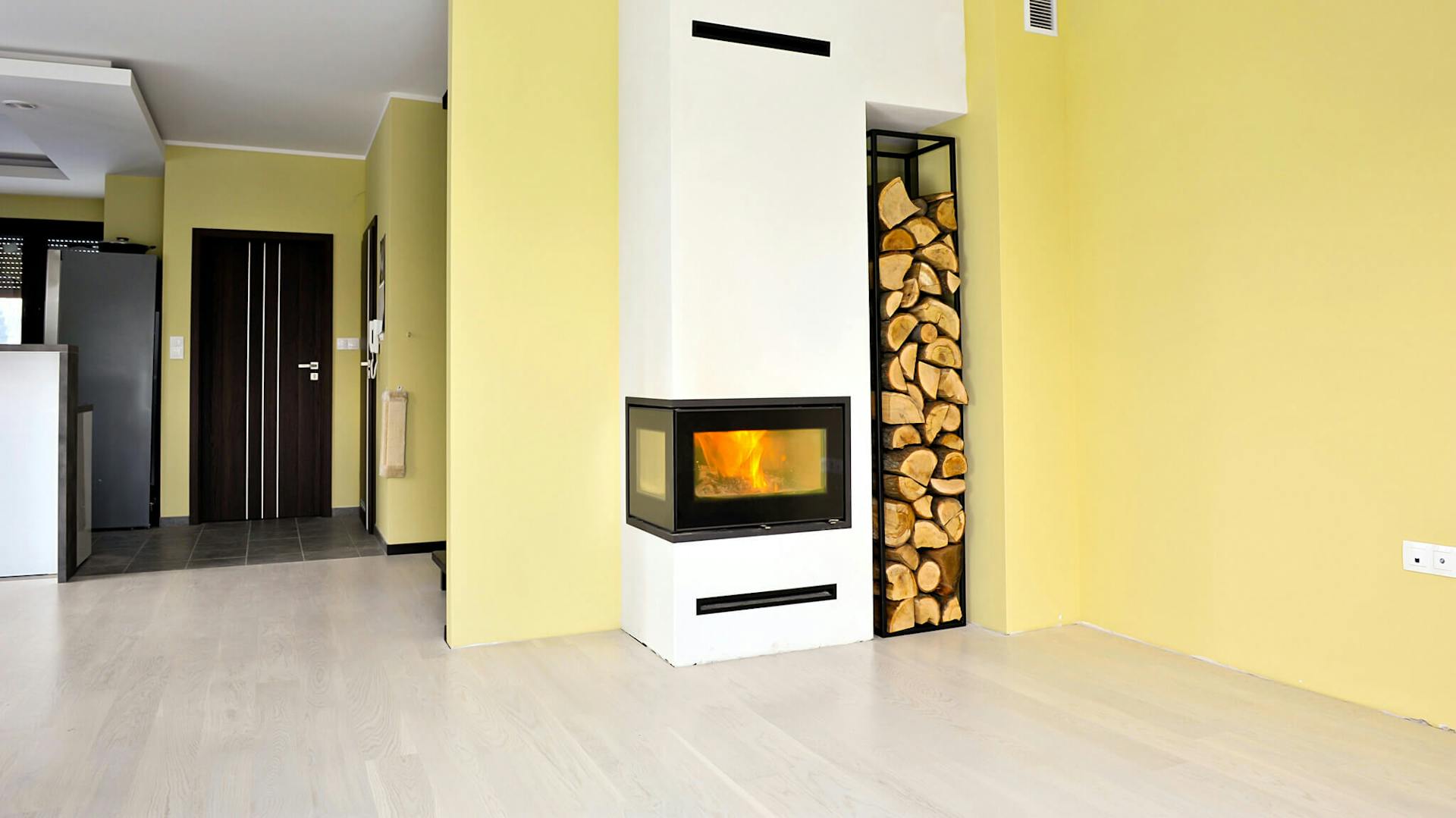 Majsterkowicze przed swoim nowym kominkiem, w którym płonie ogień.