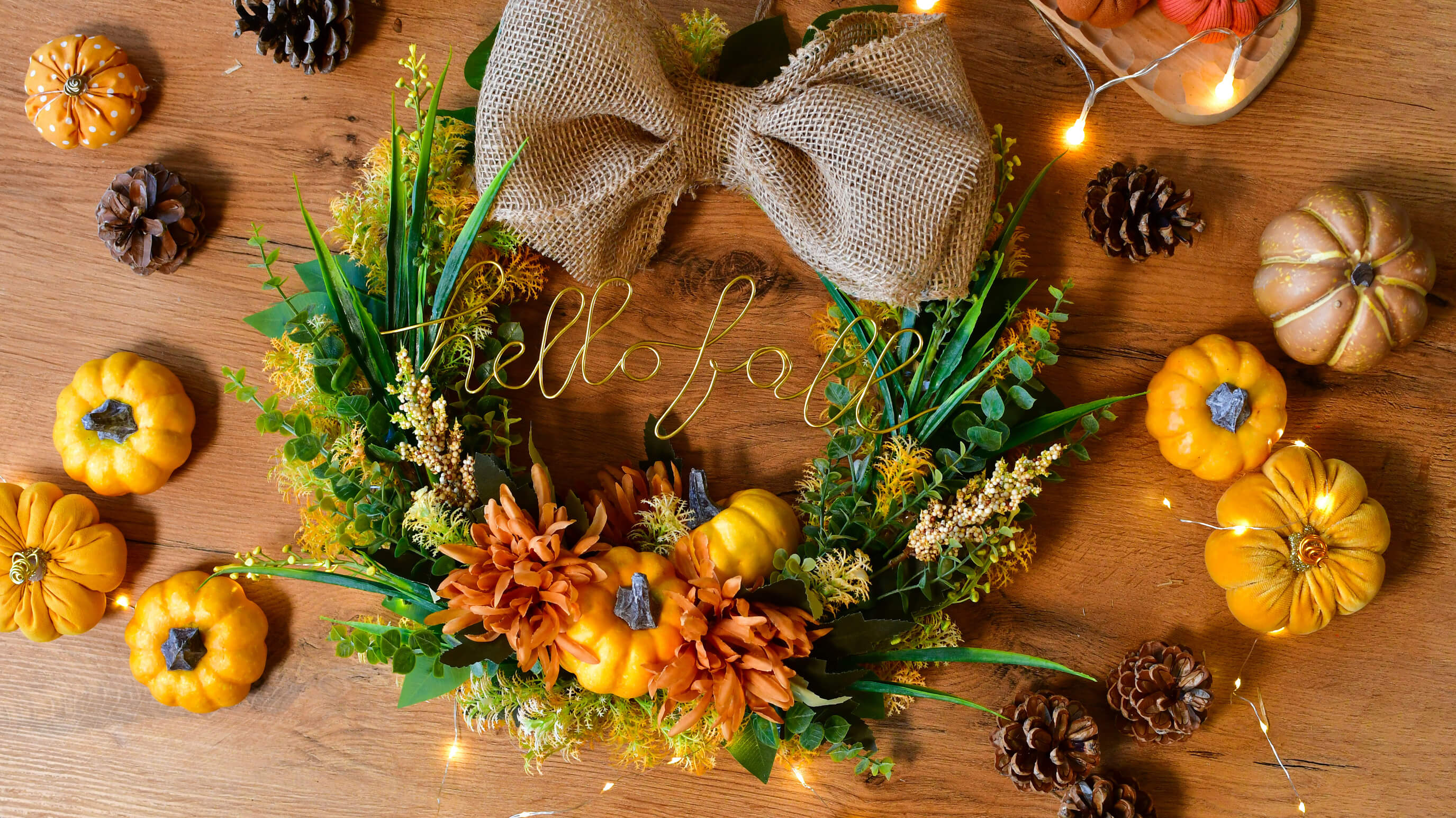 Prezentacja wykończenie jesiennego wieńca diy na drzwi jutową kokardą i napisem hello fall.