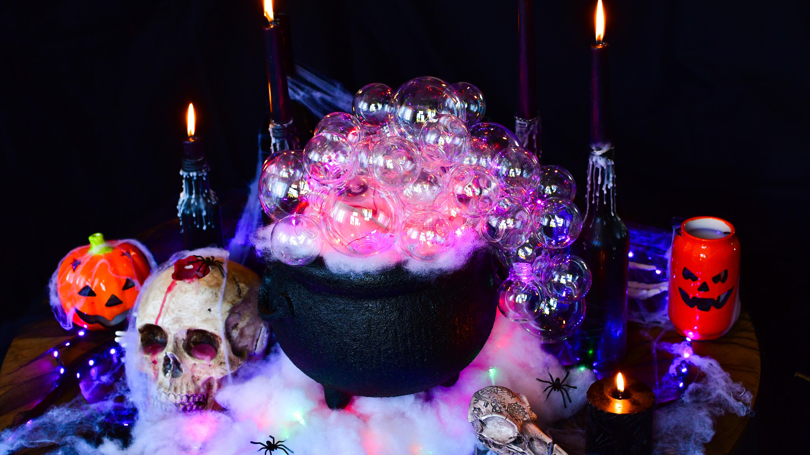 Kociołek czarownicy otoczony upiornymi ozdobami na Halloween