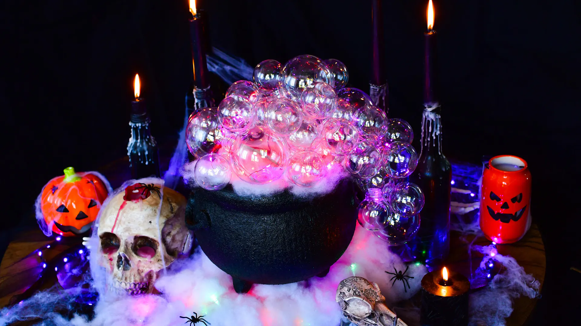 Kociołek czarownicy otoczony upiornymi ozdobami na Halloween
