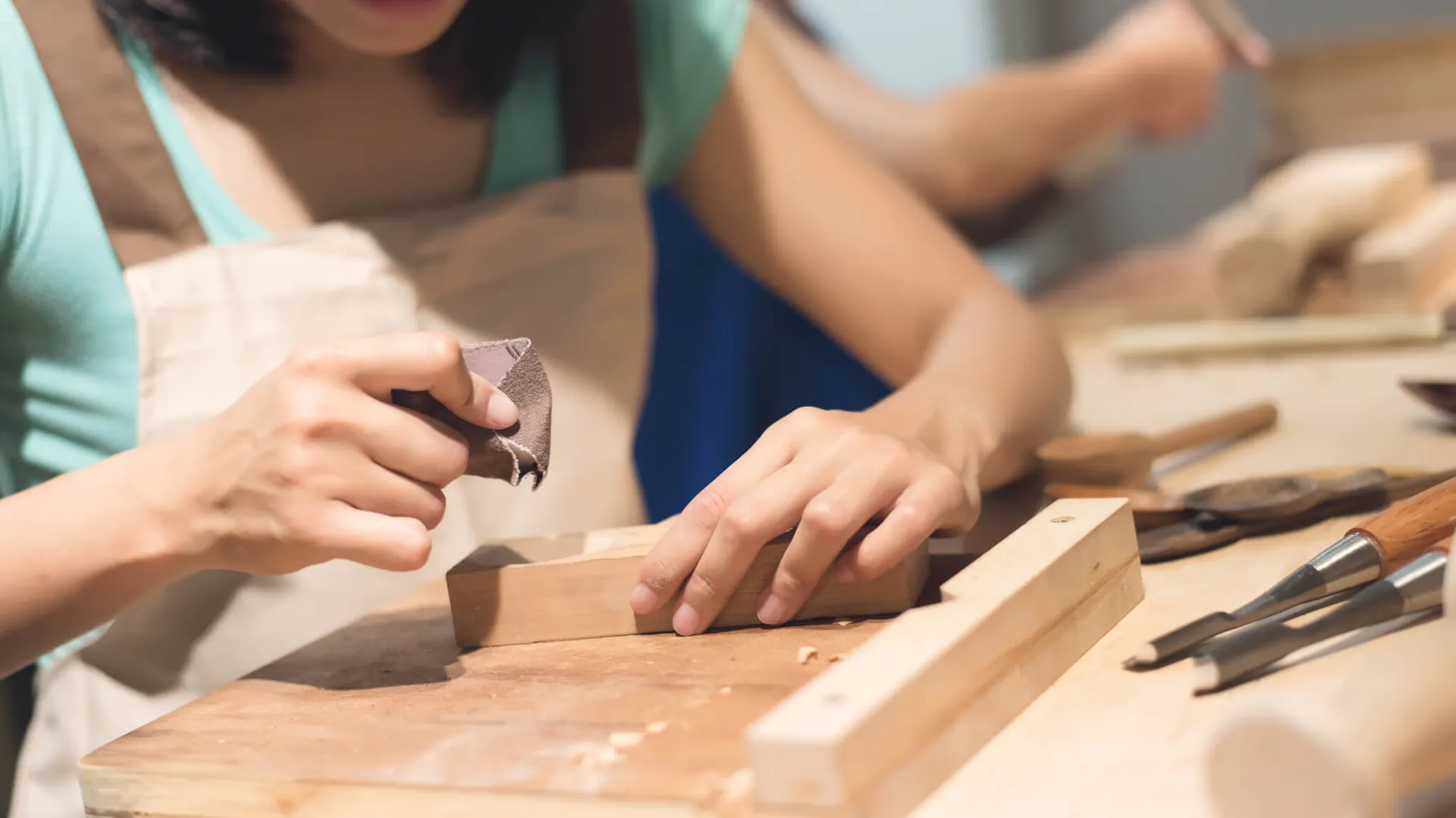 Kobieta szlifująca drewno przeznaczone do wykonania ramki na zdjęcia DIY
