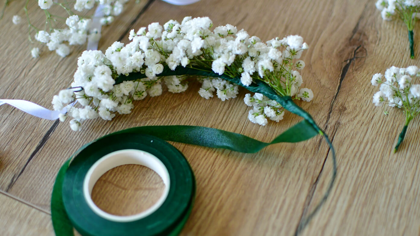 Wianek komunijny żywy – dalszy etap mocowania gipsówki na druciku przy pomocy taśmy florystycznej