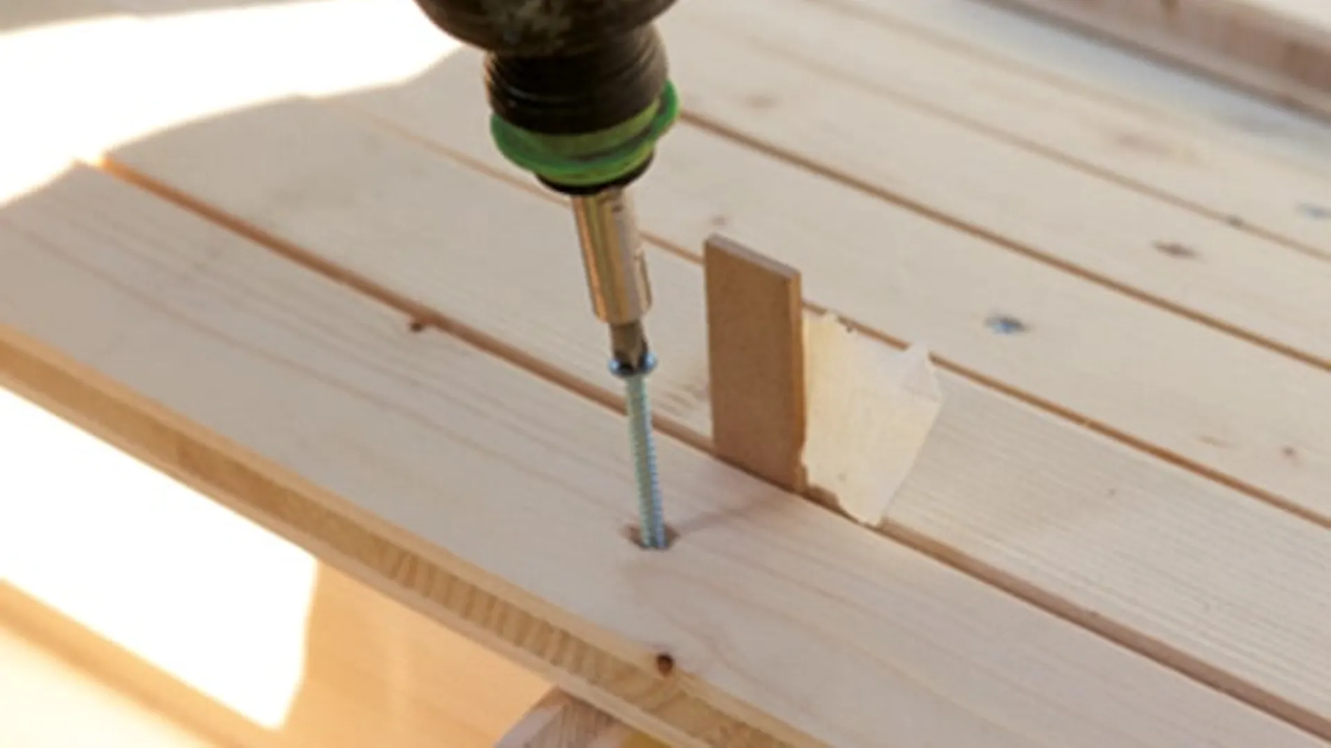 Krok 2 instrukcji DIY polega na przykręceniu listewek do stelaża huśtawki ogrodowej.