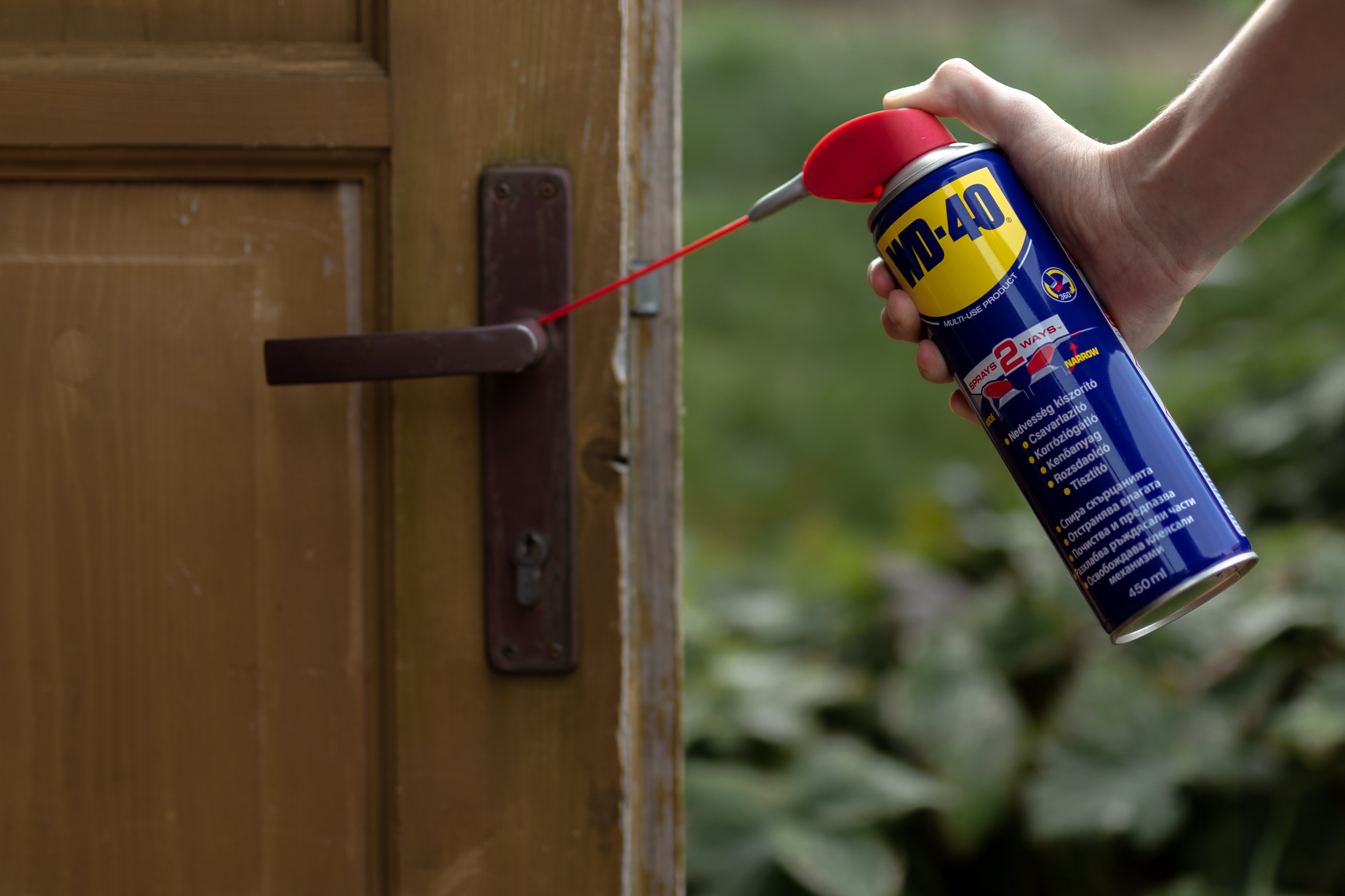 Egy kilincsre WD-40-et fújnak.