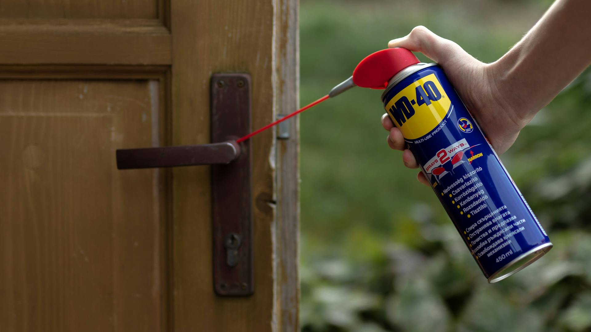 Egy kilincsre WD-40-et fújnak.