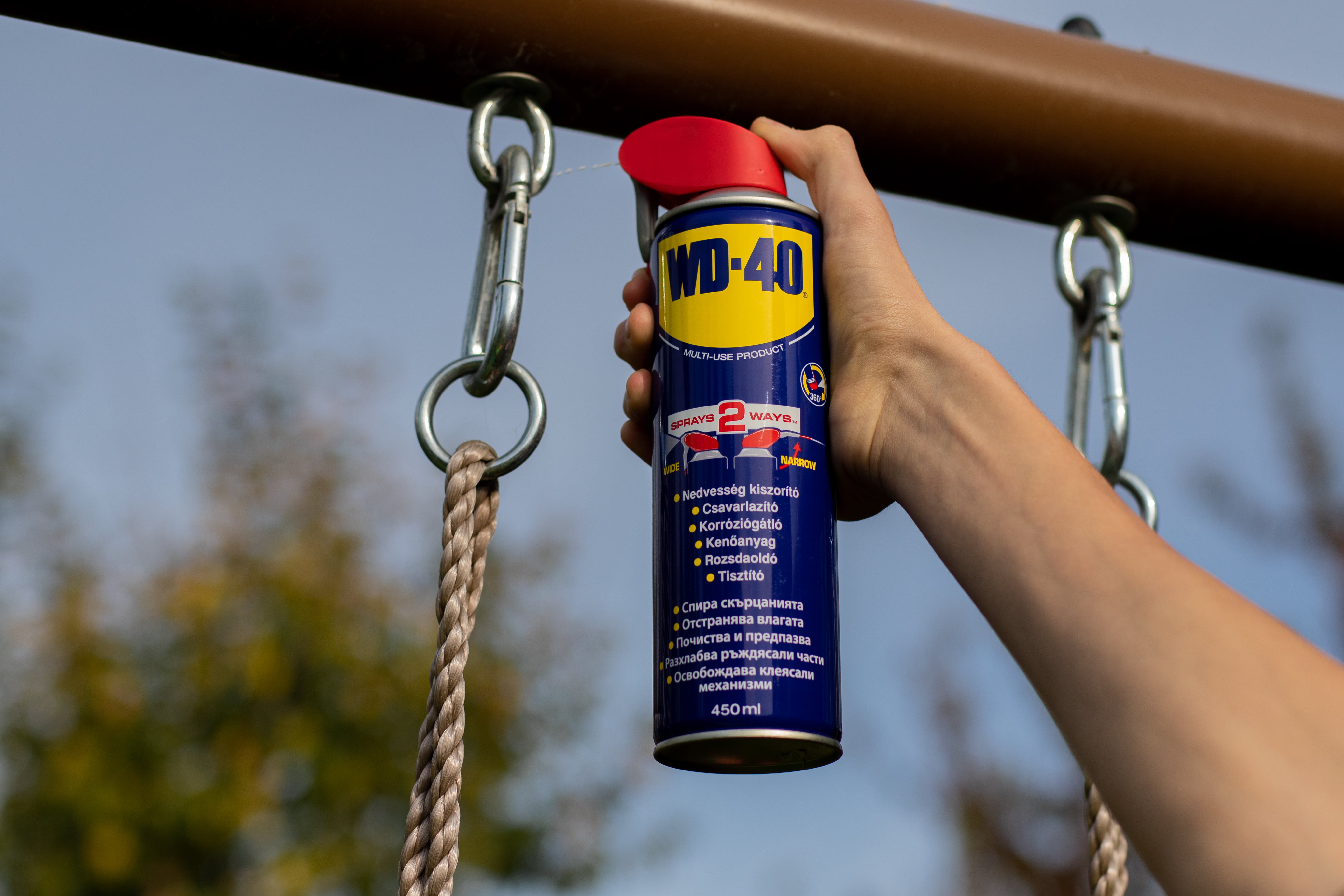 Egy hintát WD-40-nel kezelnek.